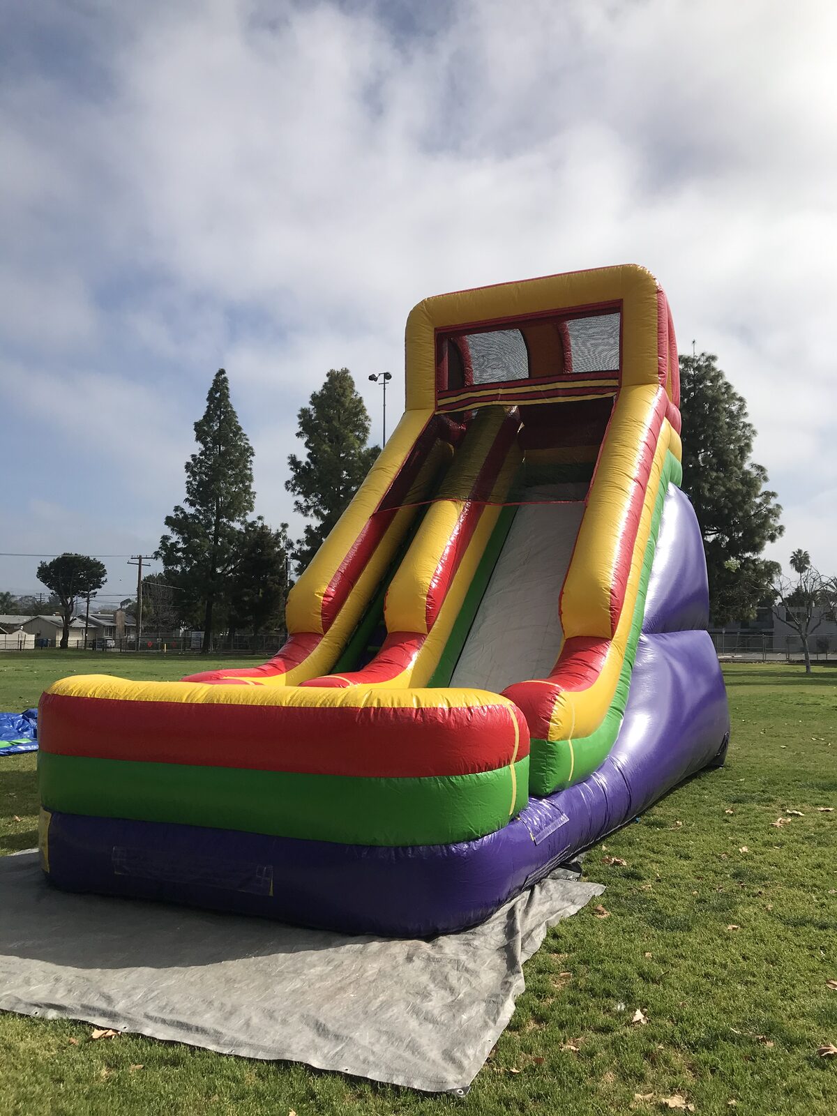 Dry slide rental in San Diego, 21ft single lane dry slide angled view showing its full towering height