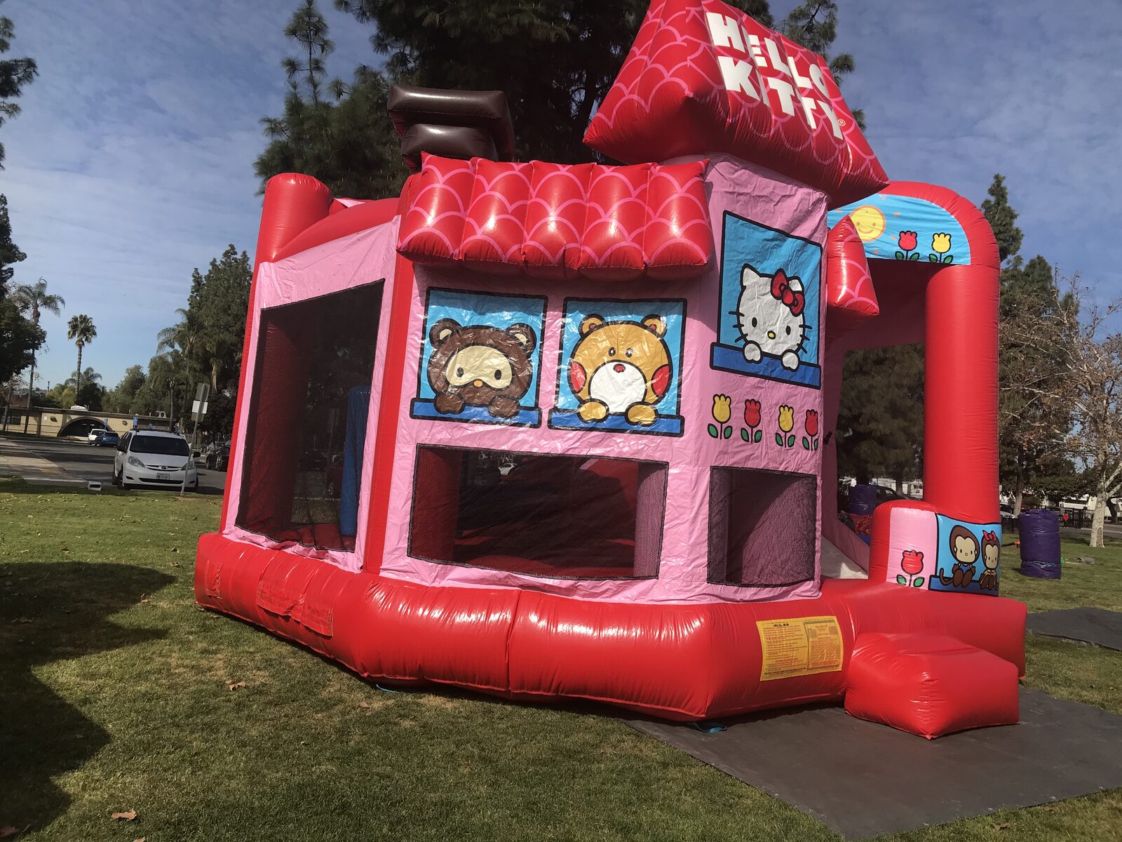 5n1 hello kitty combo bounce house rental in San Diego, side angle of the teddy bear and Hello Kitty window graphics with the jump area netting