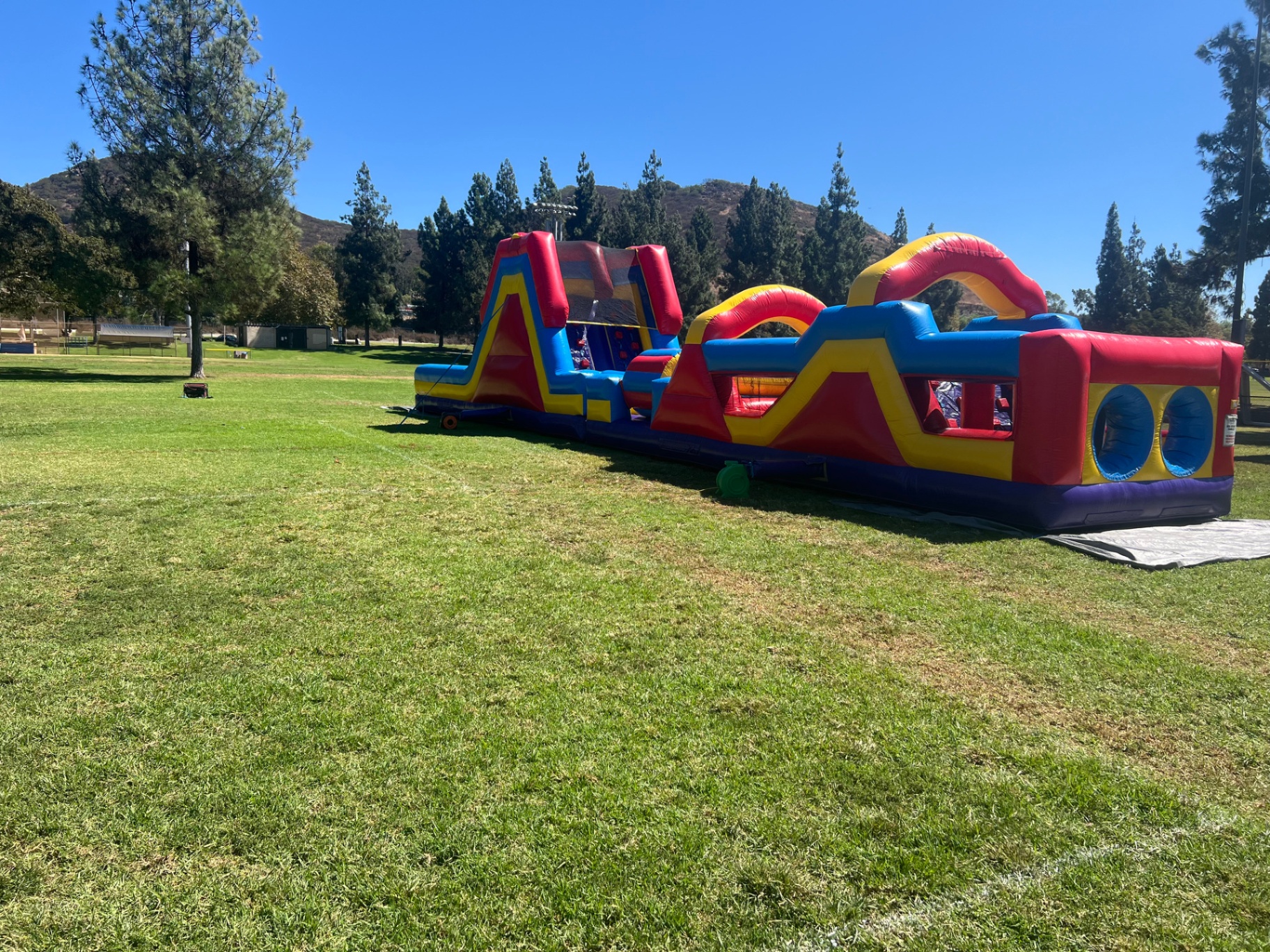 70ft monster obstacle course rental in San Diego, full-length view of the course stretched across a grass field