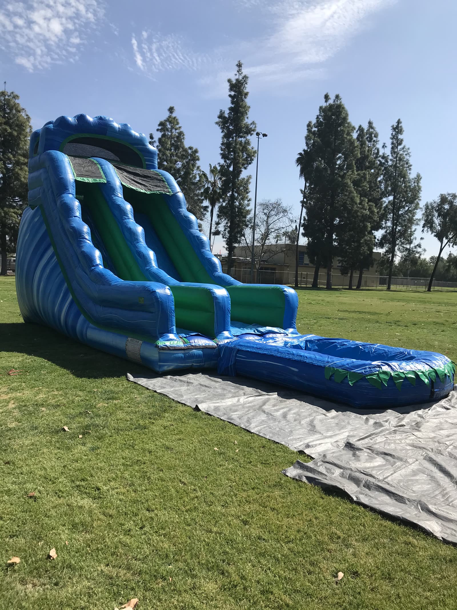 Water slide rental in San Diego, 20ft green and blue water slide wide view showing the splash pool landing and ground tarp