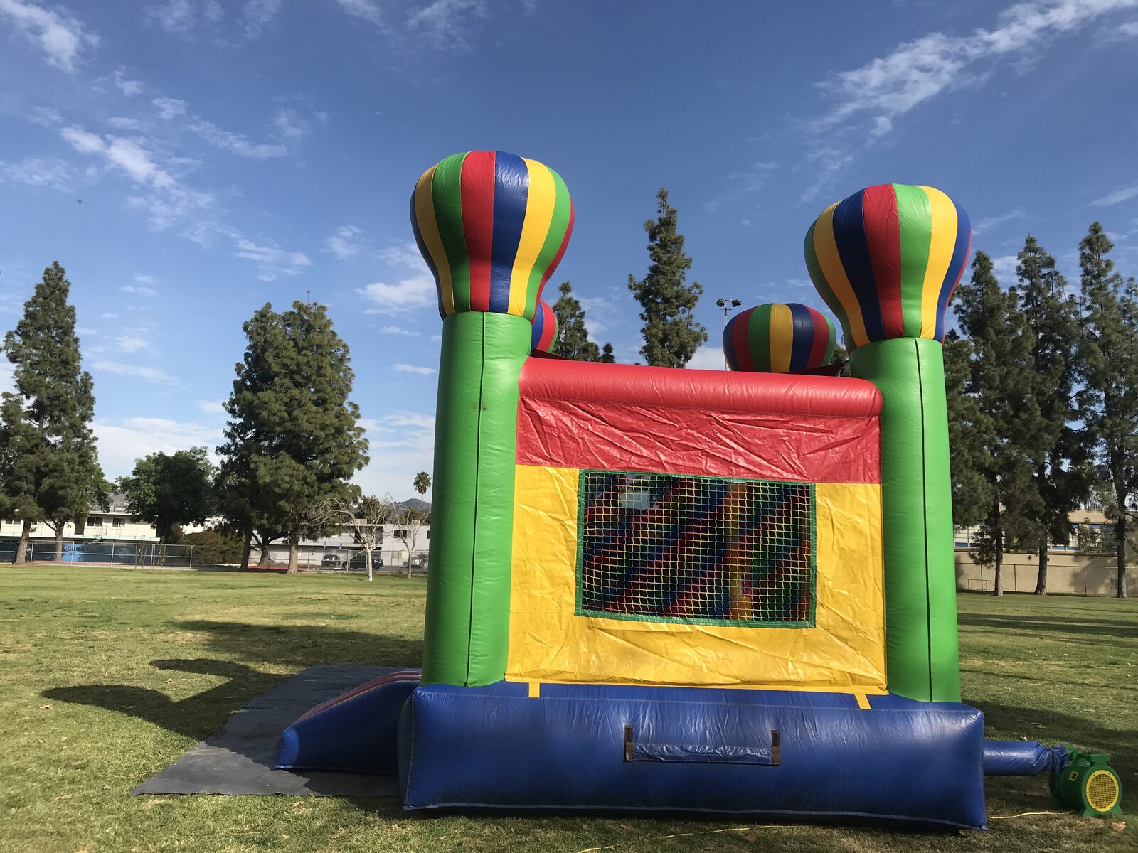 4n1 balloon castle combo bounce house rental in San Diego, rear view of the yellow wall with mesh window and green balloon-topped columns