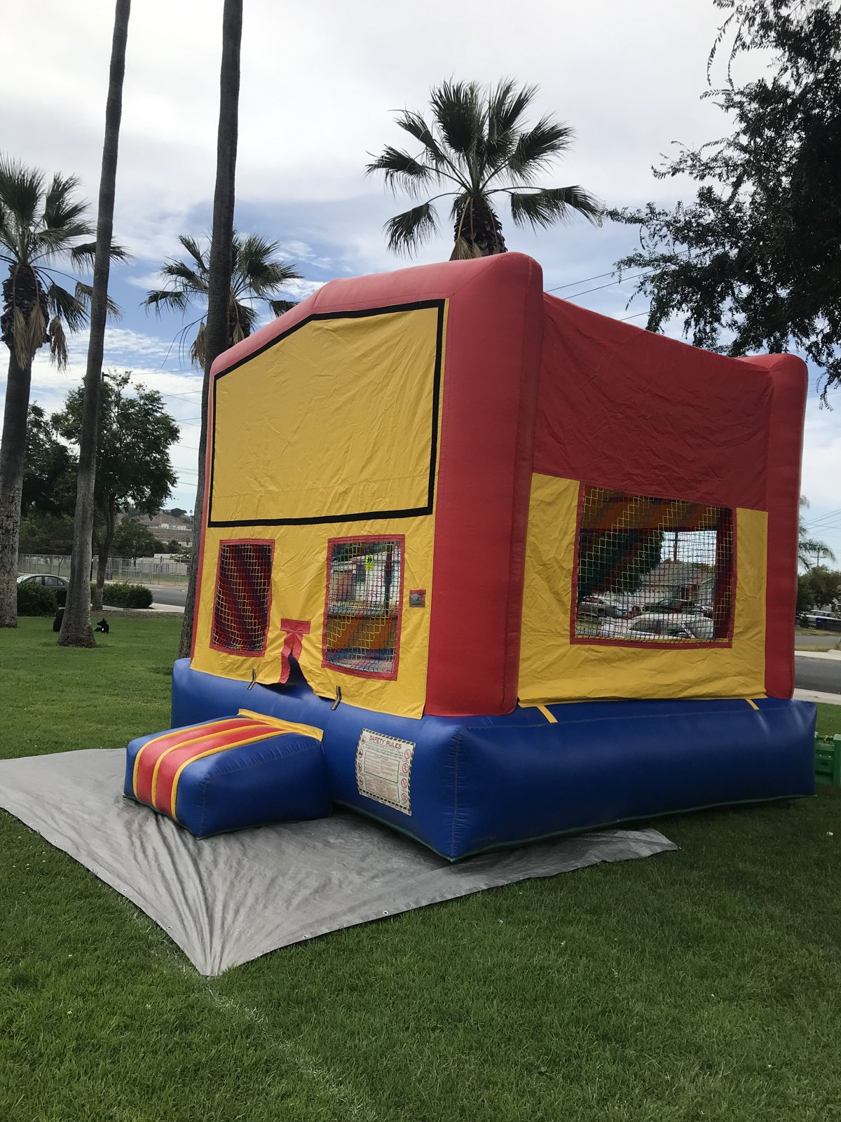 13x13 regular banner bounce house rental in San Diego — side view showing mesh safety windows