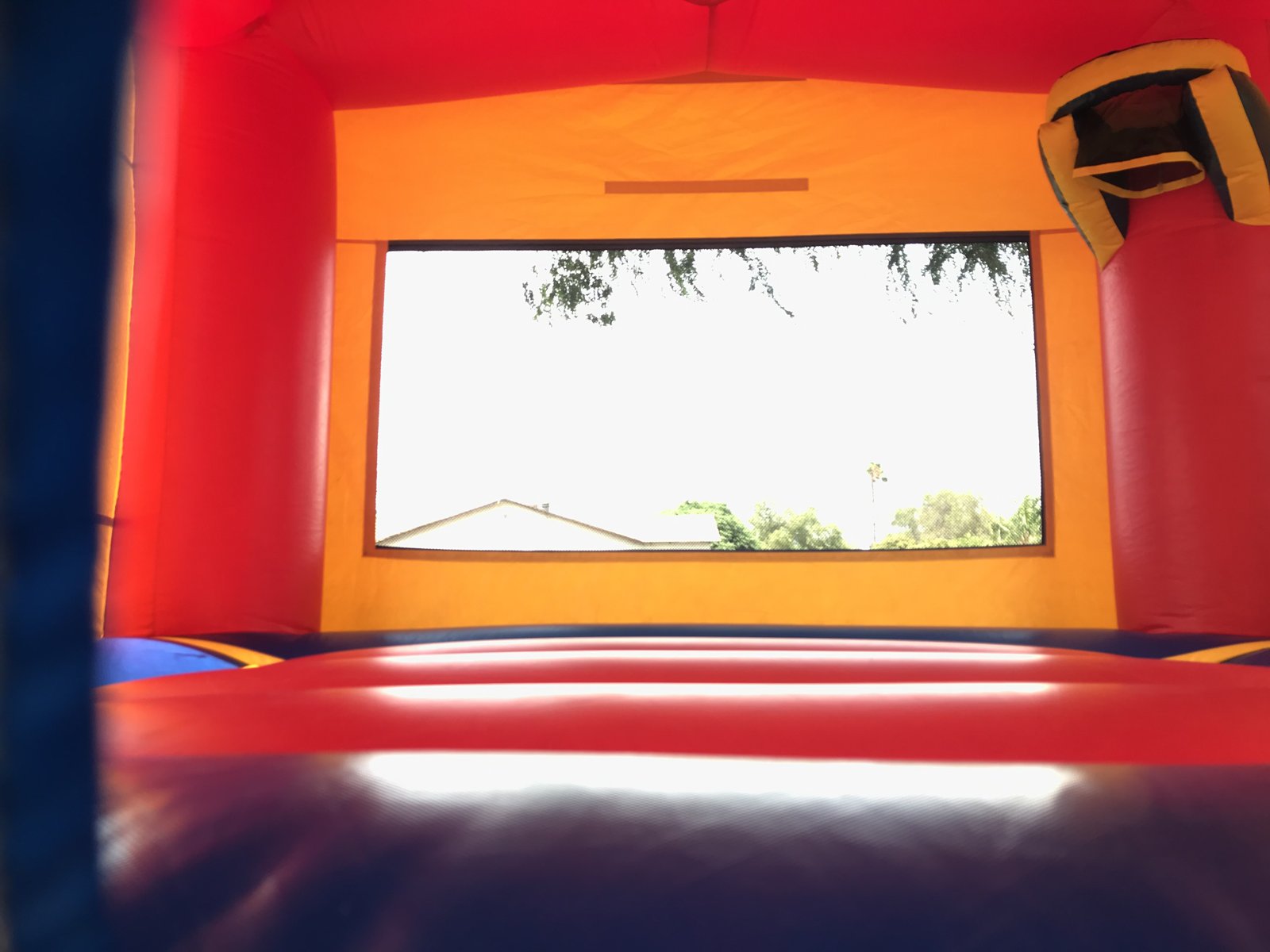 13x13 Blue Castle Banner bounce house rental in San Diego — inside view of the jumping floor with basketball hoop and large mesh window