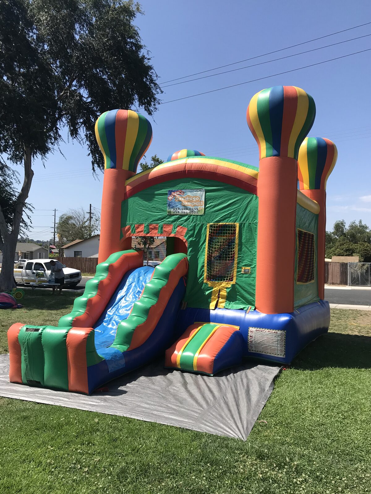 2n1 summer balloon combo bounce house rental in San Diego, side view of the slide with landing bumper set up on park grass