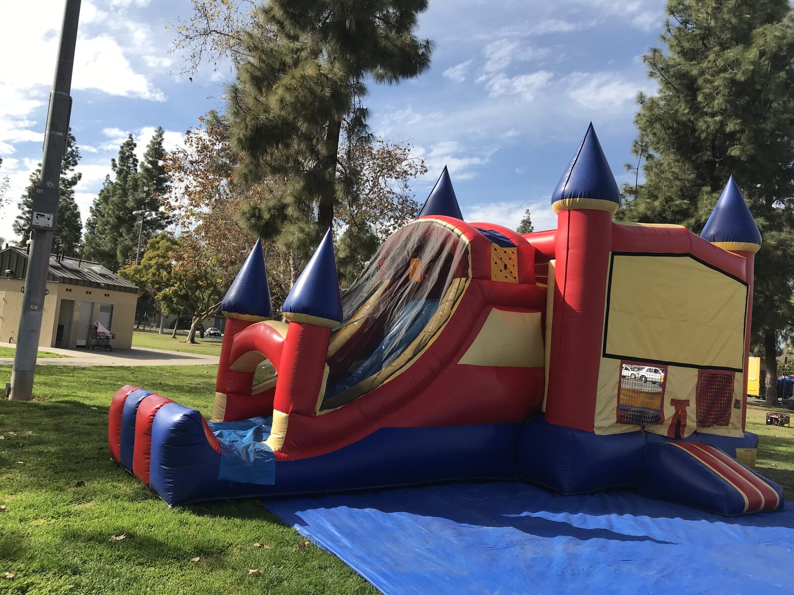 4n1 blue castle banner combo bounce house rental in San Diego, angled view of the covered slide lane and landing