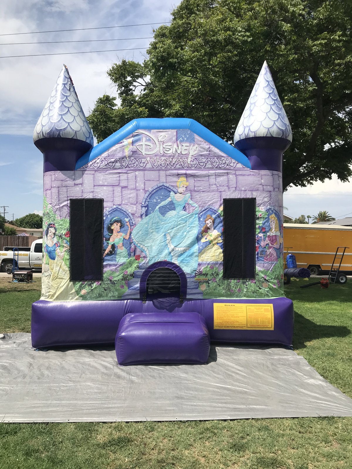 13x13 Disney Princess bounce house rental in San Diego — straight-on front view of the purple castle with silver turret toppers and Cinderella, Snow White, Belle, Jasmine, and Aurora artwork