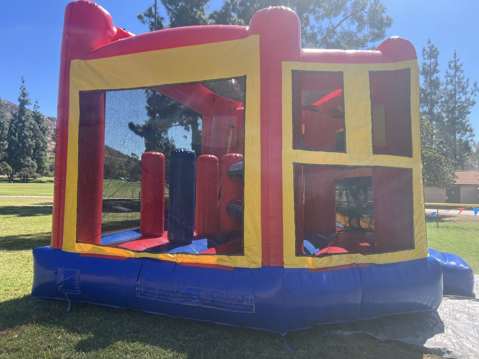 5n1 blue banner combo bounce house rental in San Diego, close-up of the mesh windows and interior obstacle course lane