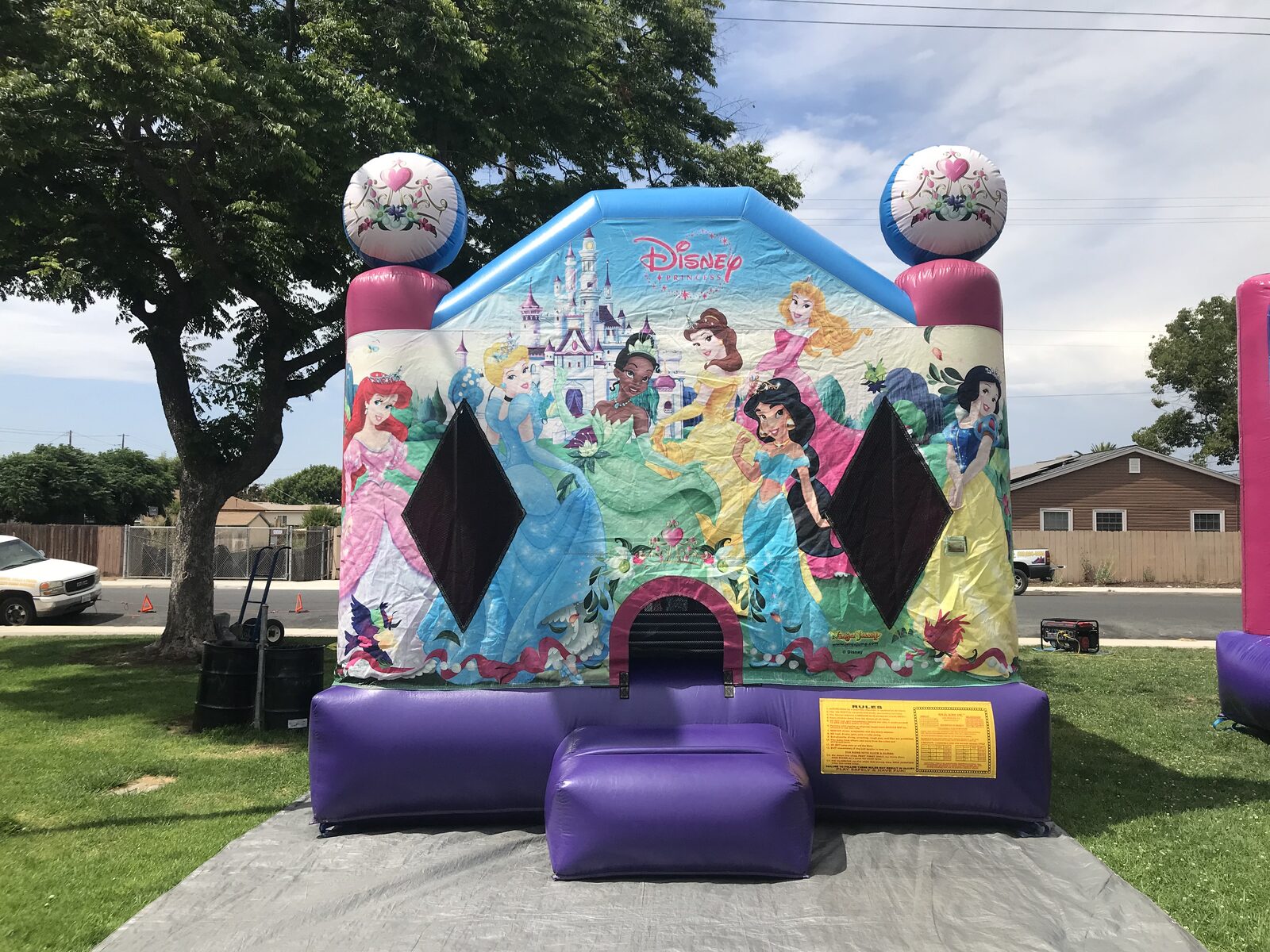 13x13 Disney Princess bounce house rental in San Diego — front view with Ariel, Cinderella, Tiana, Belle, Jasmine, and Snow White art panel and heart-crown toppers