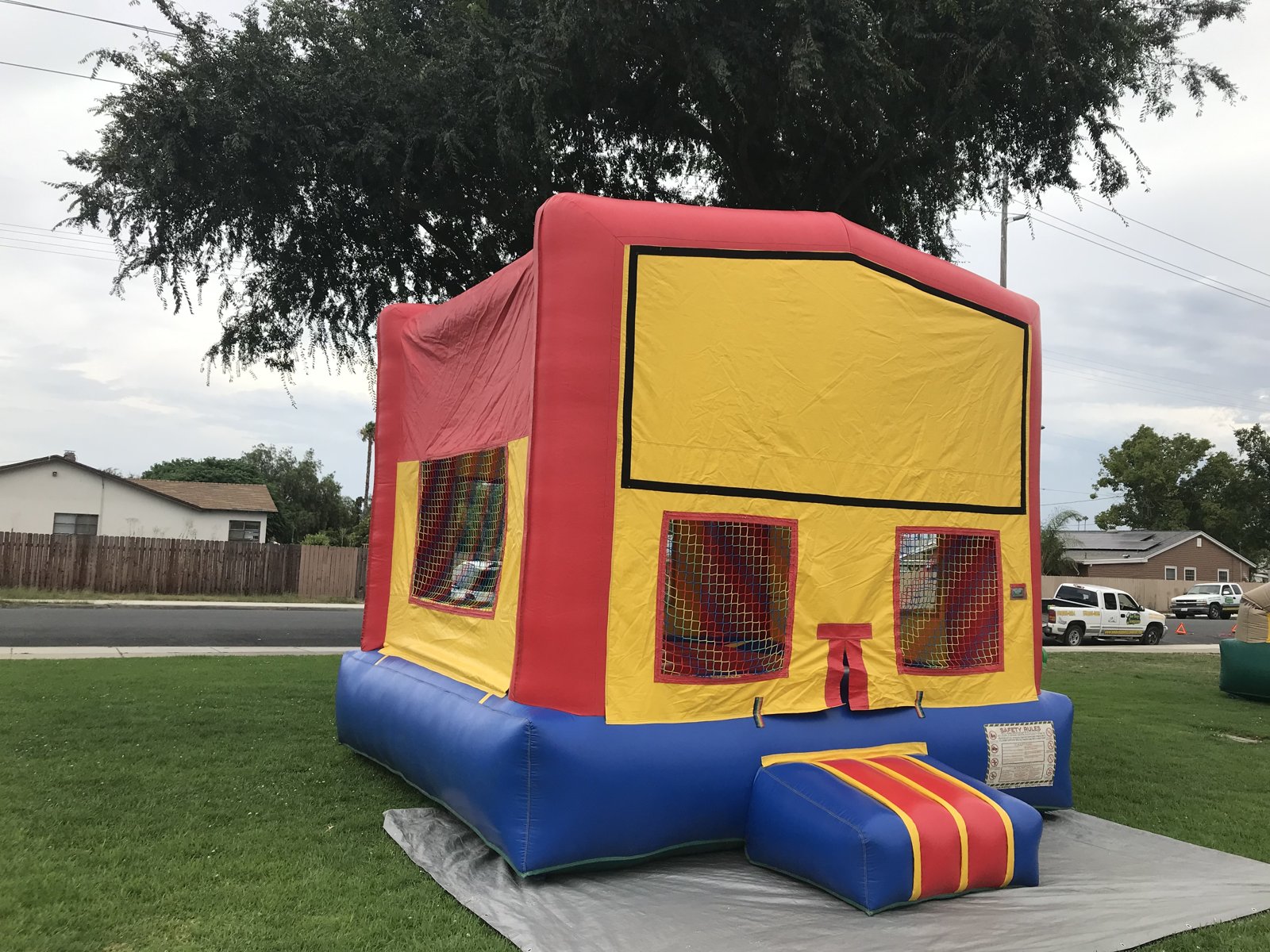 13x13 regular banner bounce house rental in San Diego — angled view set up on grass