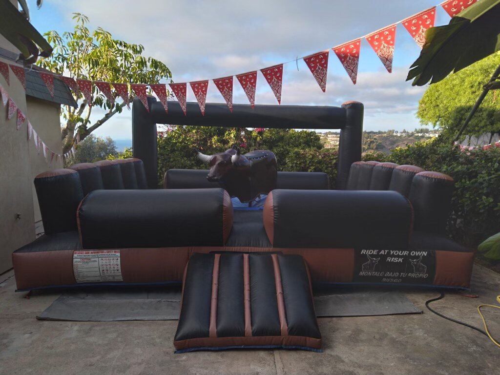 Mechanical bull rental in San Diego, 13x13 setup on a backyard patio with cowboy-themed decorations