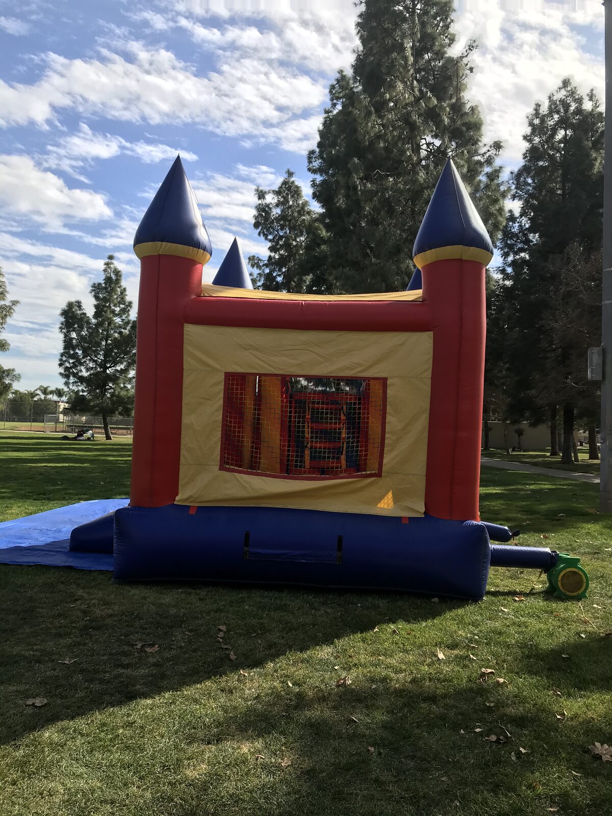 4n1 blue castle banner combo bounce house rental in San Diego, back view of the castle wall with mesh window and blower hooked up