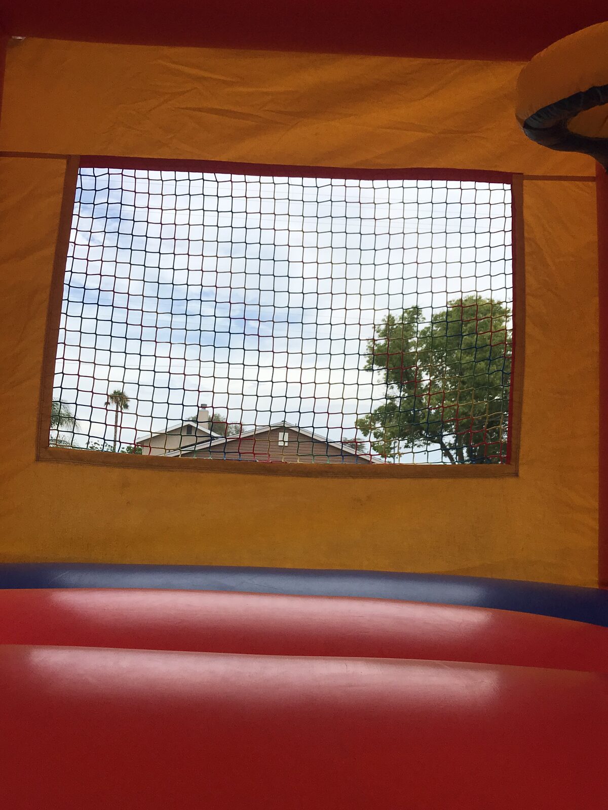 12x14 blue castle mini bounce house rental in San Diego, interior view through the mesh window