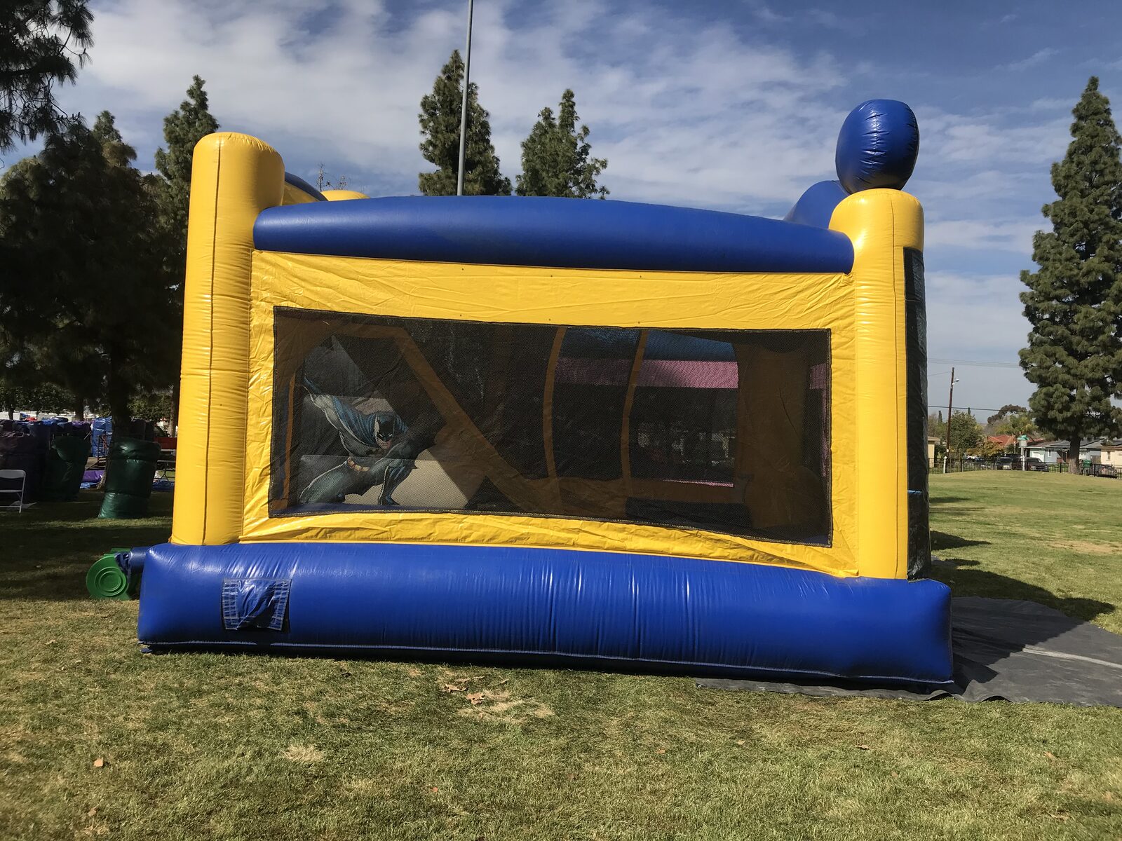 4n1 Batman combo bounce house rental in San Diego, side view of the yellow and blue wall with long mesh window
