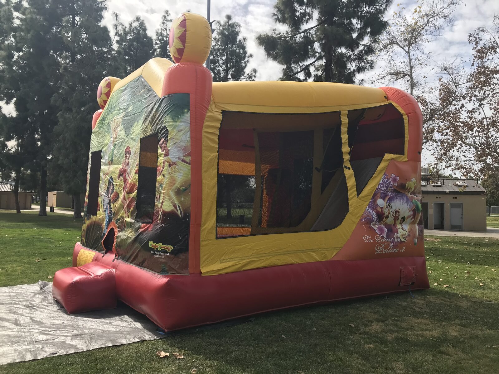 4n1 fairies combo bounce house rental in San Diego, angled view showing the sunflower top towers and the shaded jump area inside