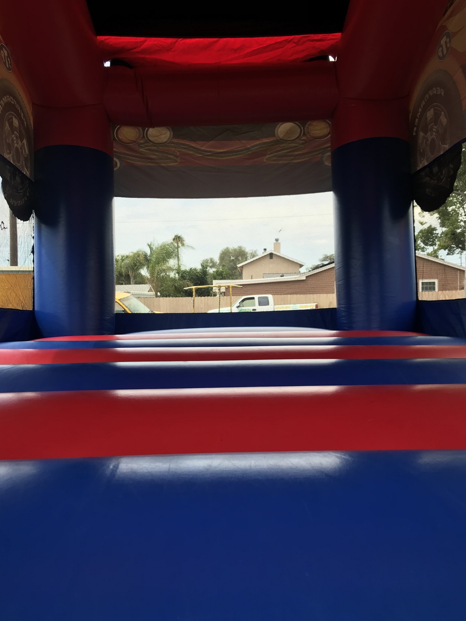 13x17 Xtreme Racer bounce house rental in San Diego — inside view of the red, white, and blue jumping floor looking out the mesh window