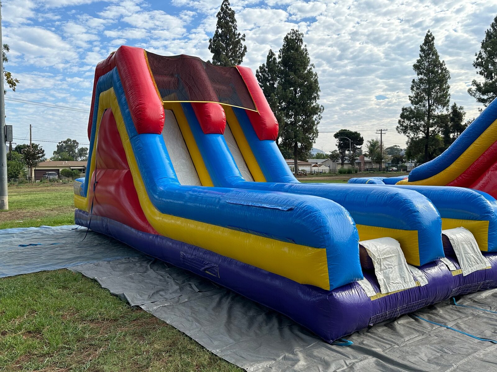 18ft dual lane monster obstacle course rental in San Diego, low angle along the racing lanes at a school field