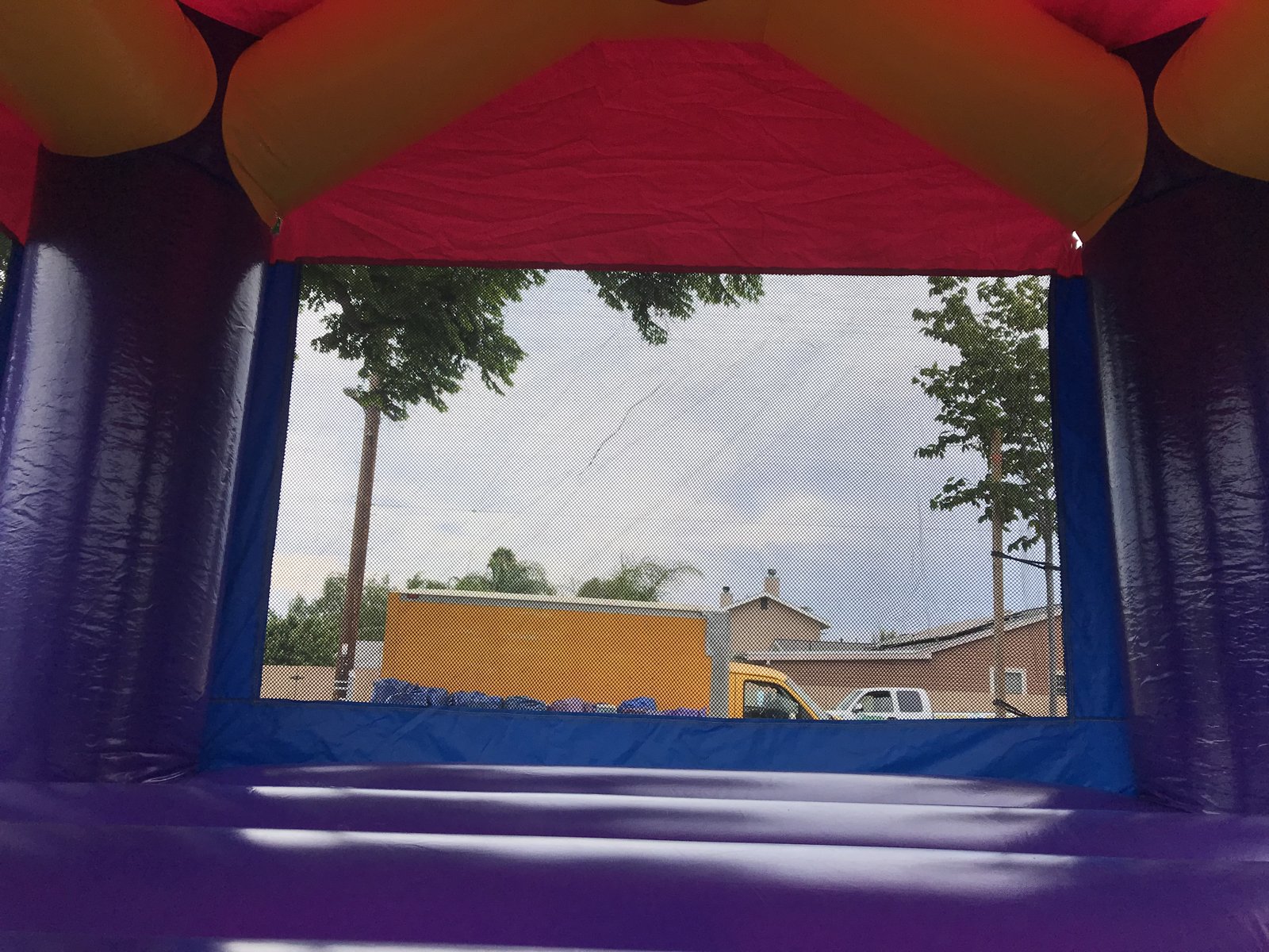 13x13 Dream Castle Model 2 bounce house rental in San Diego — inside view of the purple jumping floor looking out the large mesh window