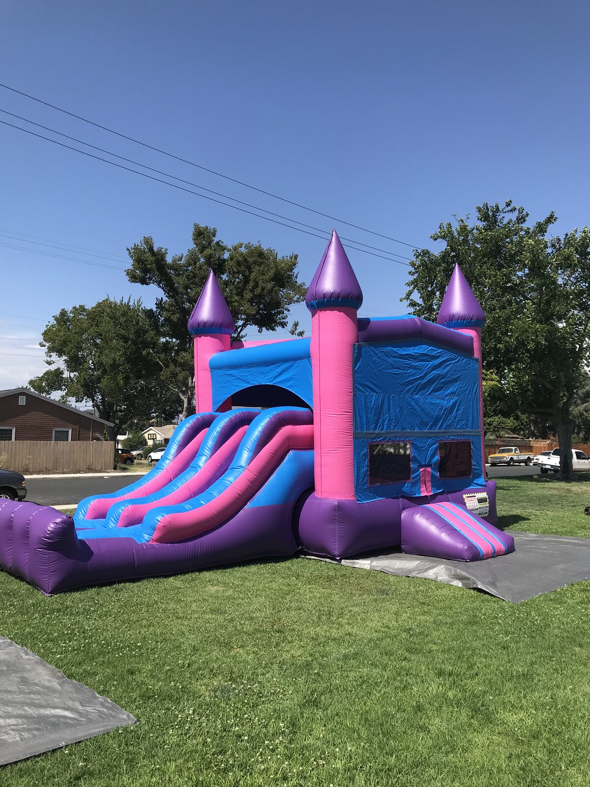3n1 pink castle banner combo bounce house rental in San Diego, close view of the dual slide lanes and padded landing bumper