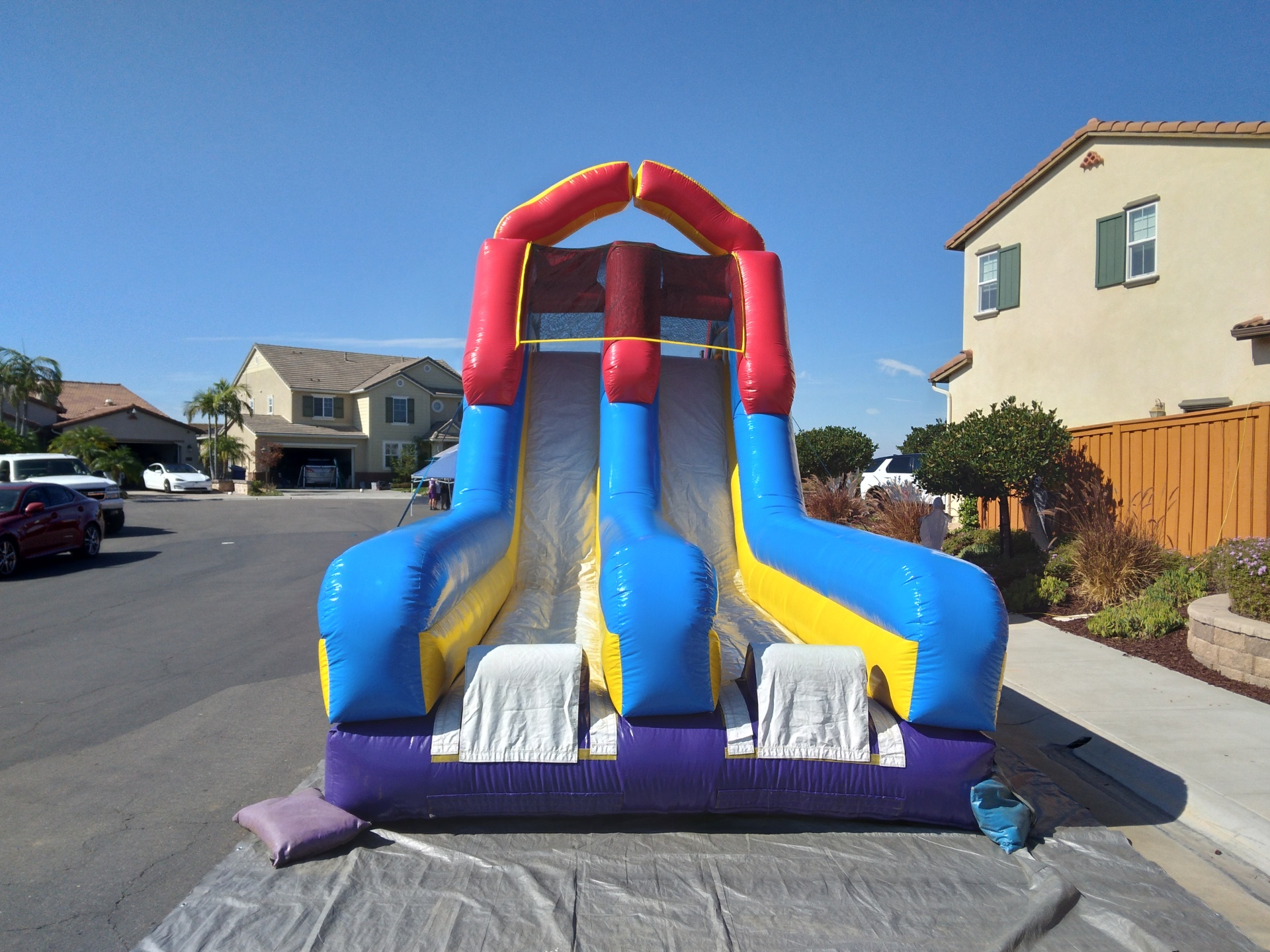 70ft monster obstacle course rental in San Diego, front view of the dual slide lanes set up on a residential driveway