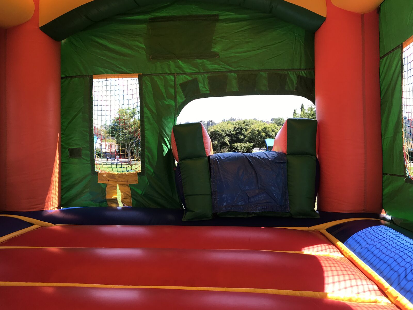 2n1 summer balloon combo bounce house rental in San Diego, inside view toward the slide climb-up and safety netting