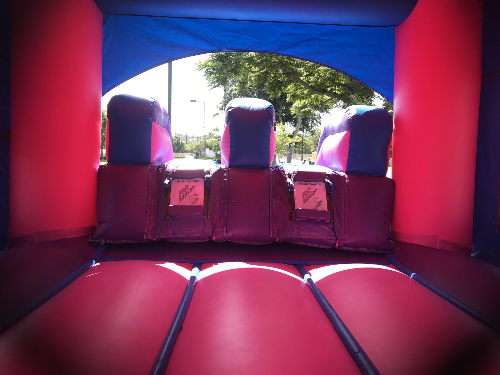 3n1 pink castle banner combo bounce house rental in San Diego, wide view of the full unit set up on a tarp at a park