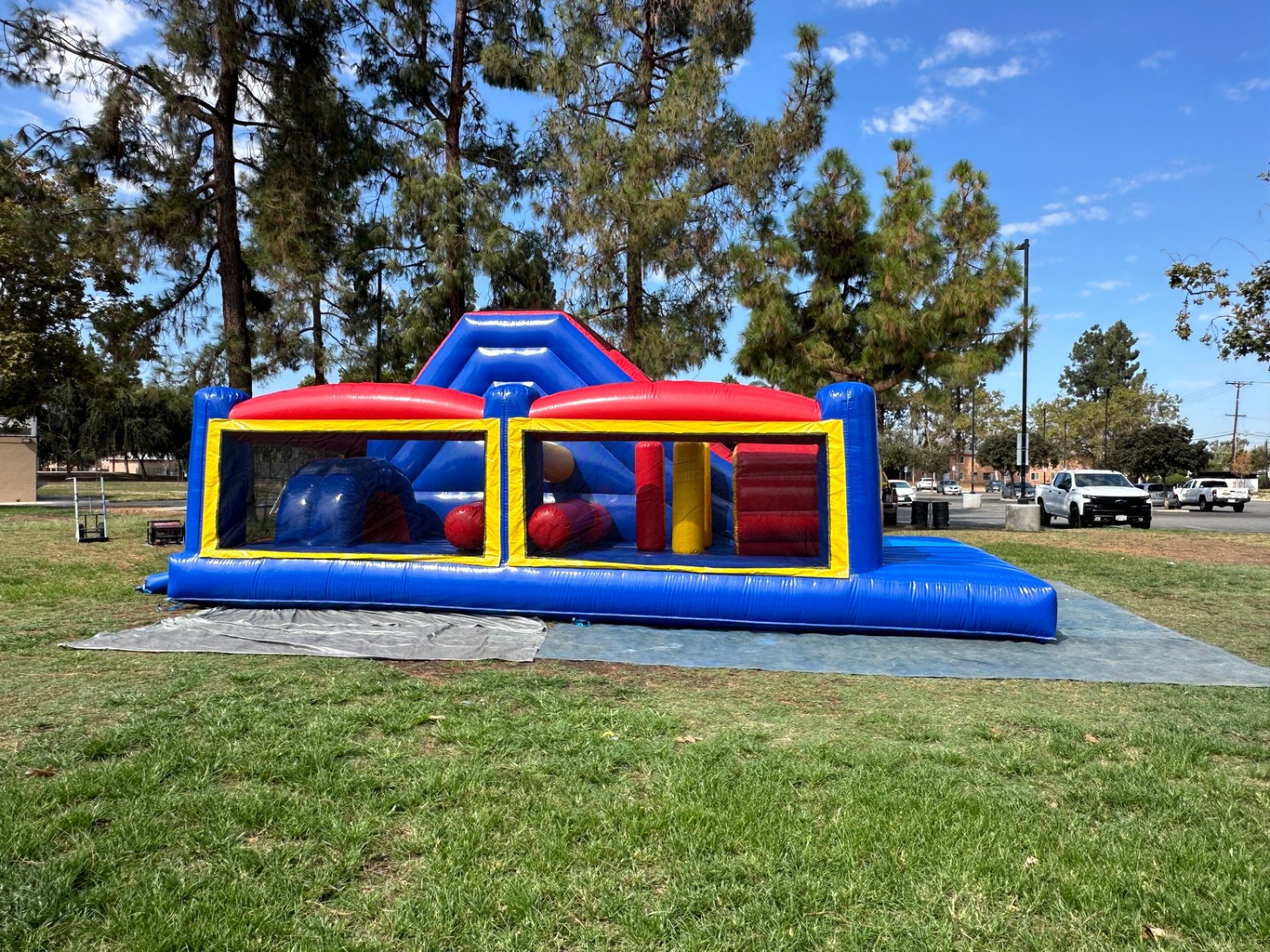 Challenge course obstacle rental in San Diego, blue and red lane, straight-on side view of the pop-up obstacles behind the mesh panels