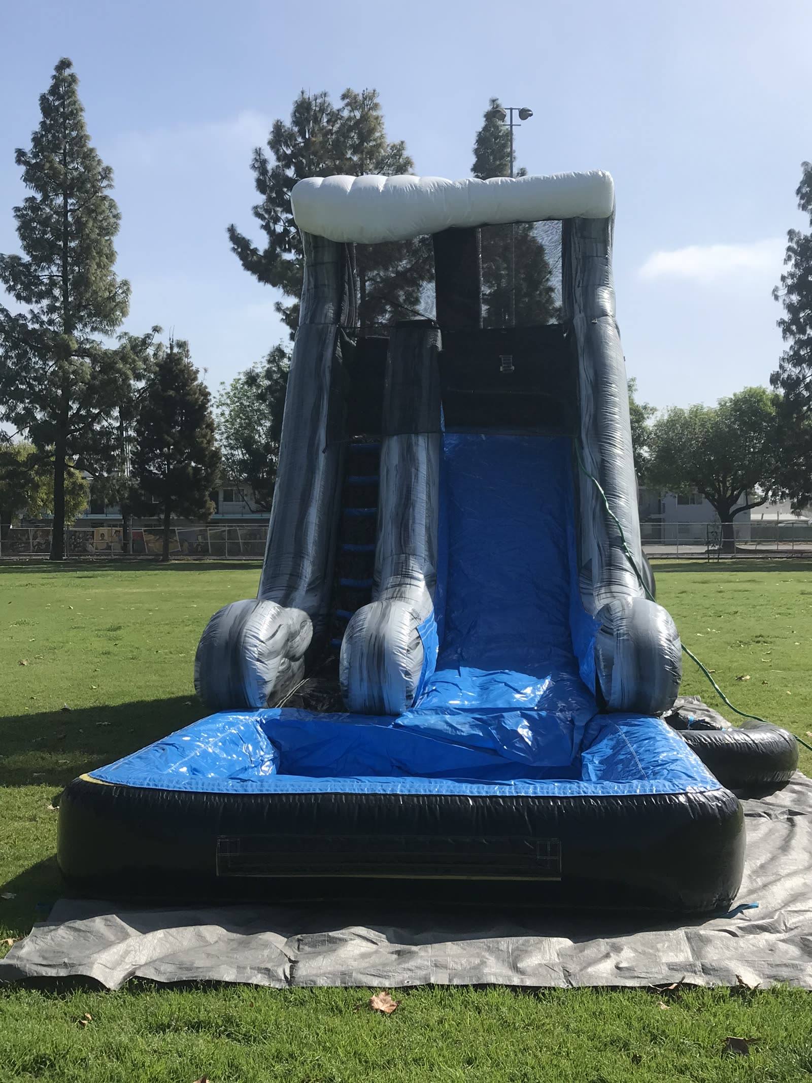 Water slide rental in San Diego, 18ft wave setup rear view showing the blower and safety netting