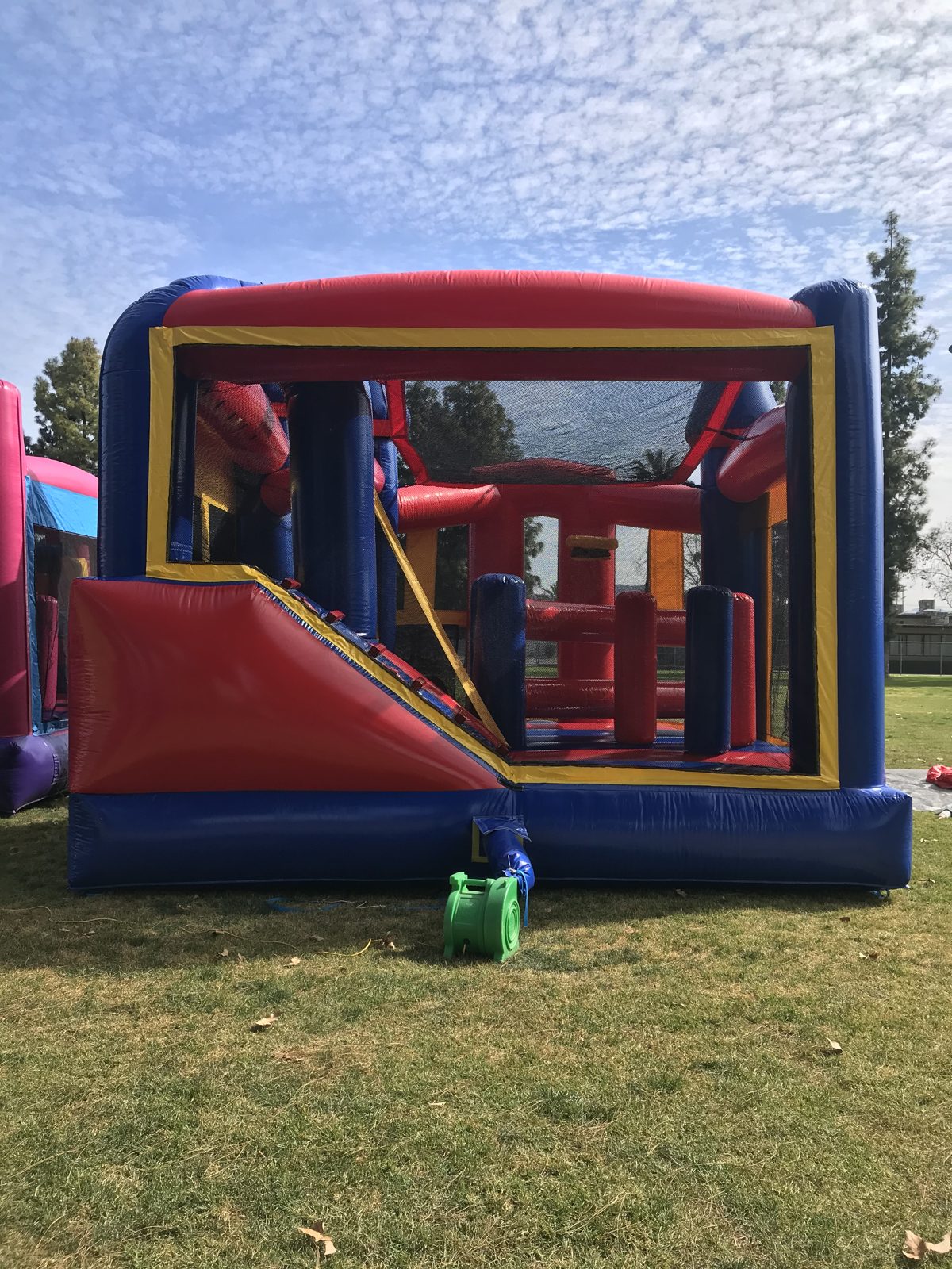 5n1 blue castle banner combo bounce house rental in San Diego, rear view of the slide exit with the blower attached