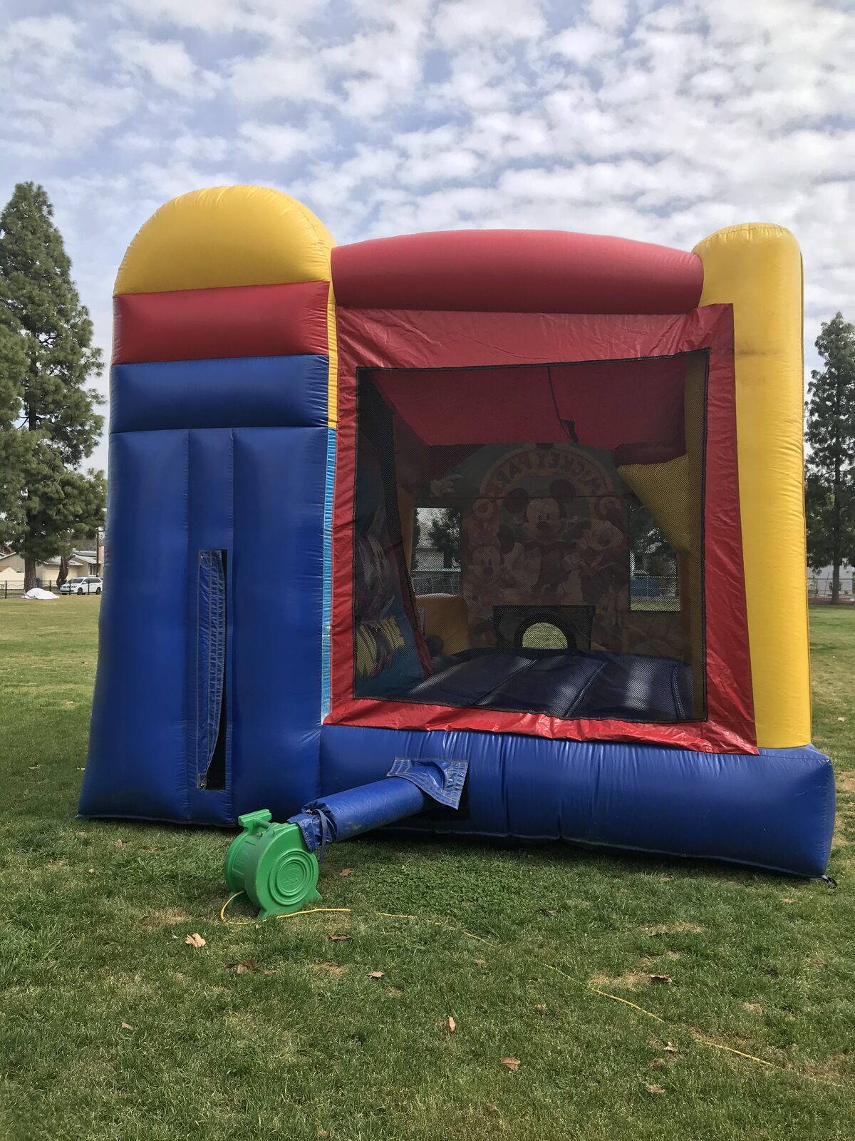 4n1 Mickey combo bounce house rental in San Diego, rear three-quarter view looking through the mesh into the jump area and climb-up