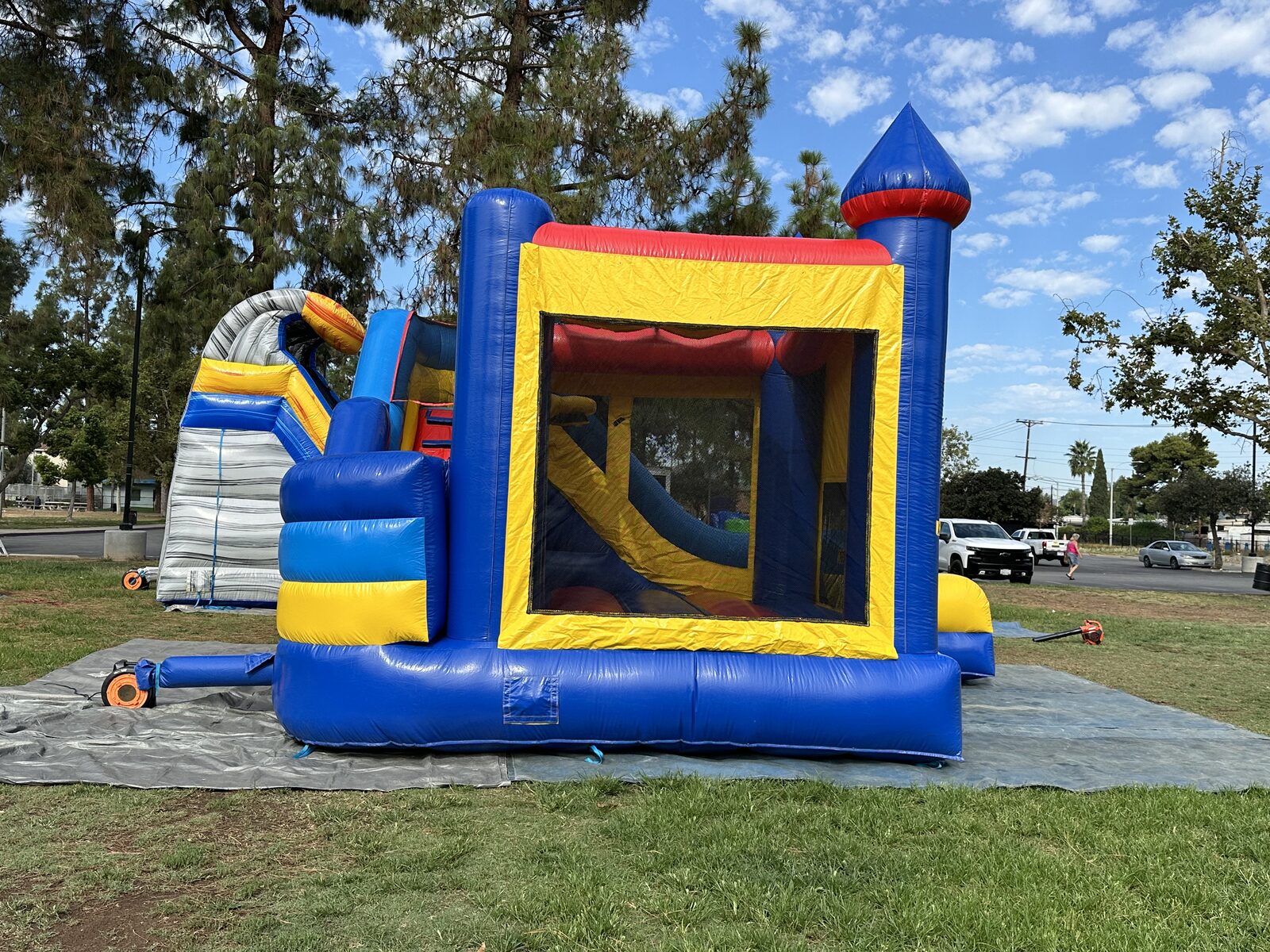 6n1 blue castle banner combo bounce house rental in San Diego, side view through the large mesh window showing the interior climb-up to the slide