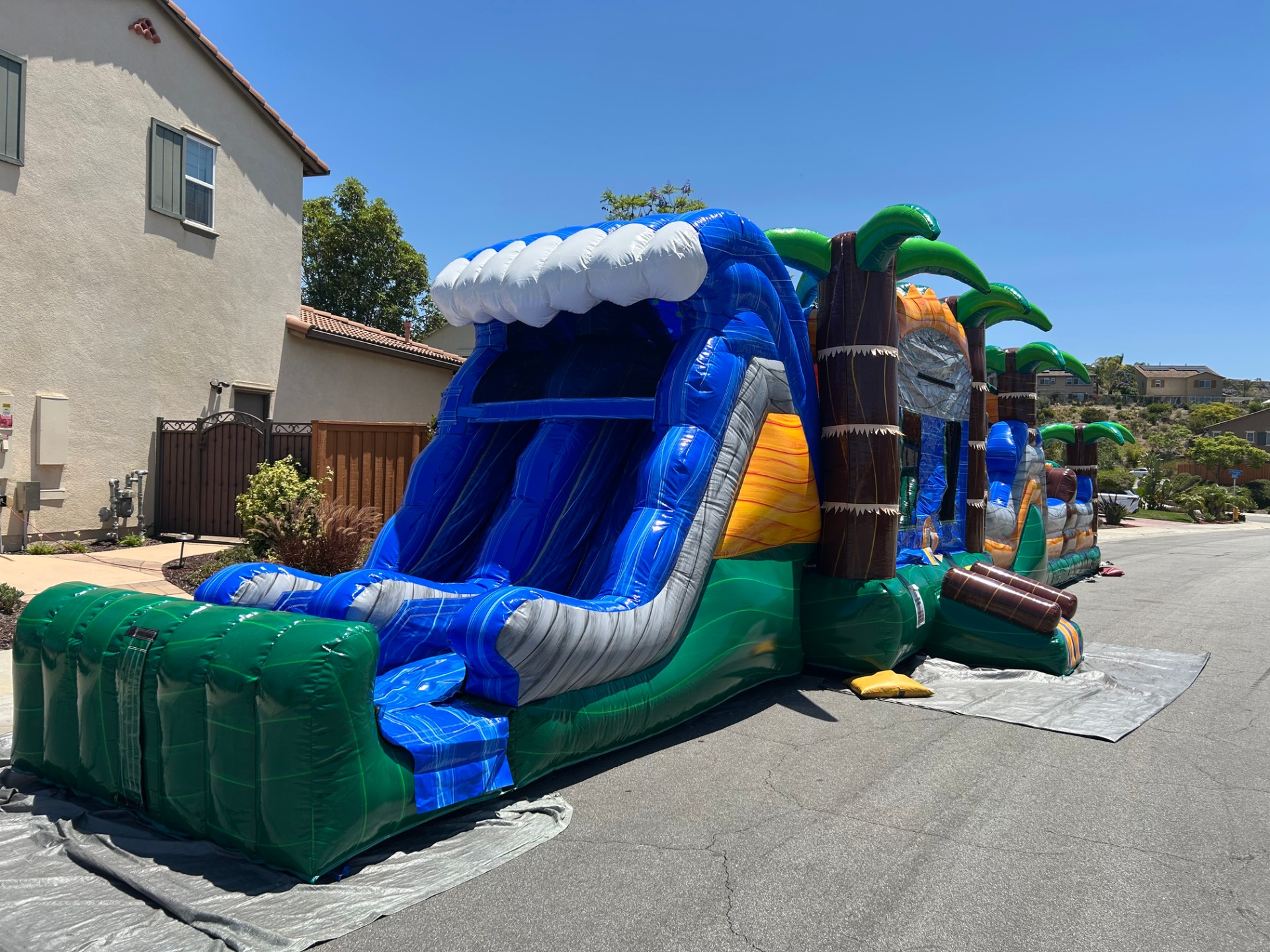 63ft tropical obstacle course rental in San Diego, side profile of the slide with the obstacle section behind