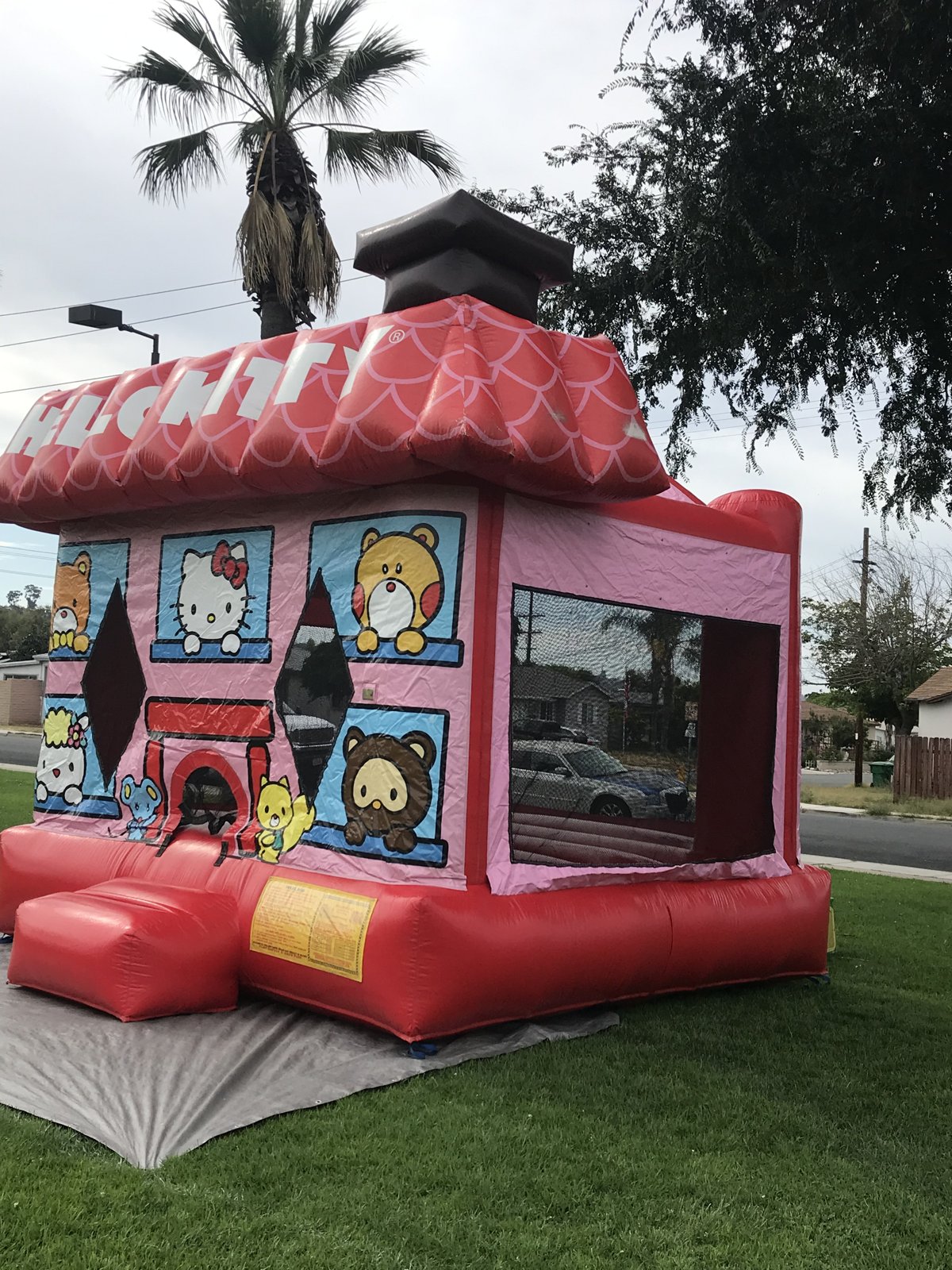 13x13 Hello Kitty bounce house rental in San Diego — three-quarter view showing the mesh side window and Hello Kitty roof lettering
