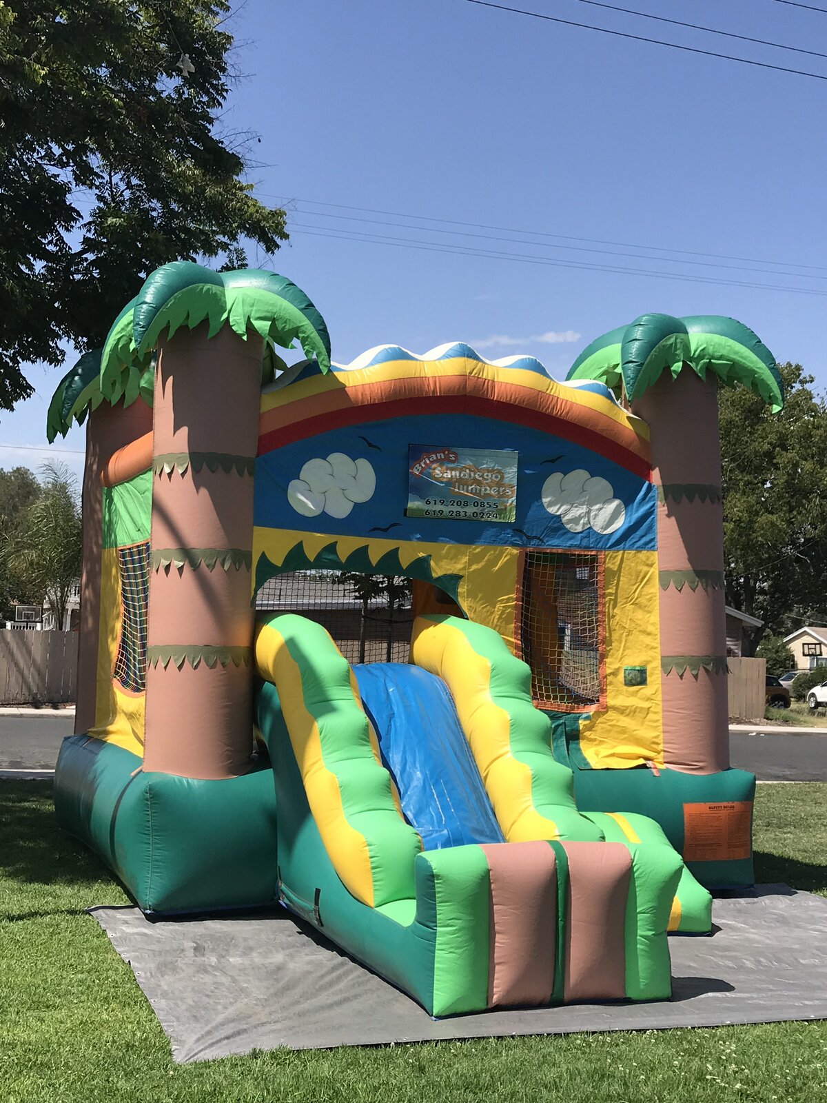 2n1 palm tree combo bounce house rental in San Diego, three-quarter view showing the full blue slide lane and mesh safety window