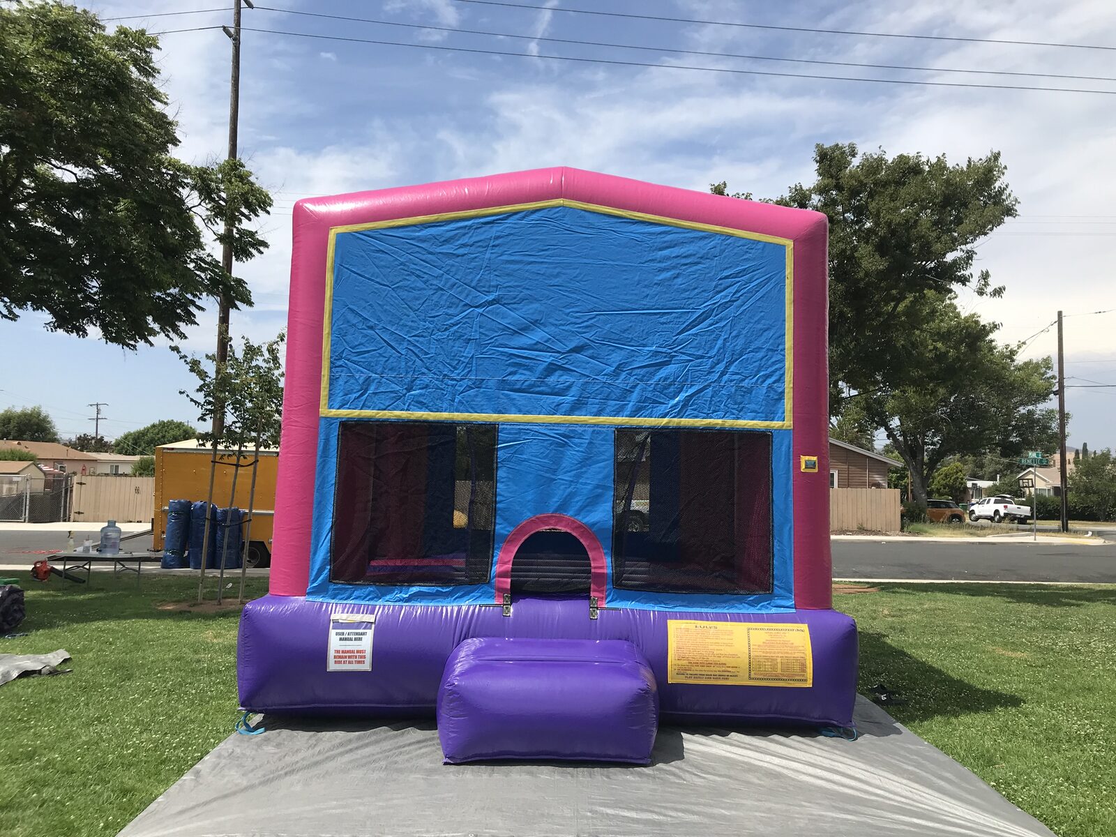 13x13 pink banner bounce house rental in San Diego — front view over a protective tarp with the yellow-trimmed blank banner panel