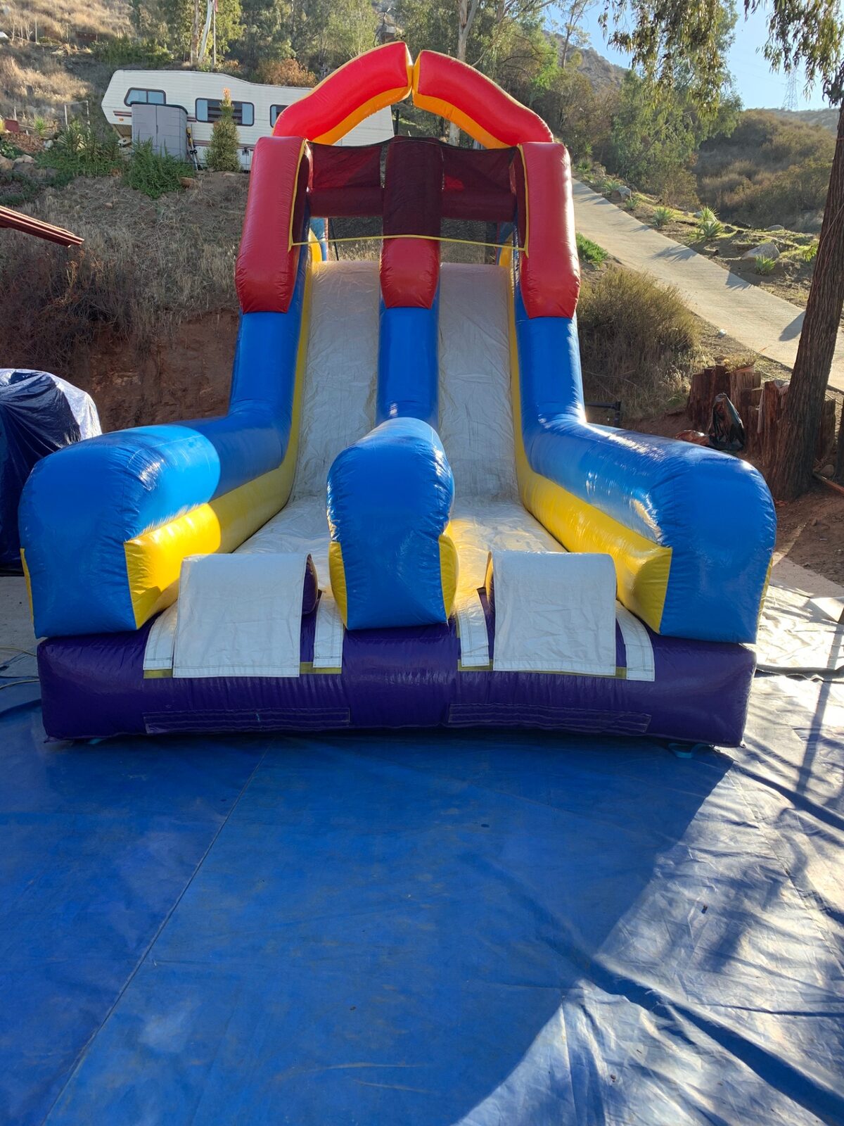 18ft dual lane monster obstacle course rental in San Diego, front view of the twin slide lanes on a driveway tarp