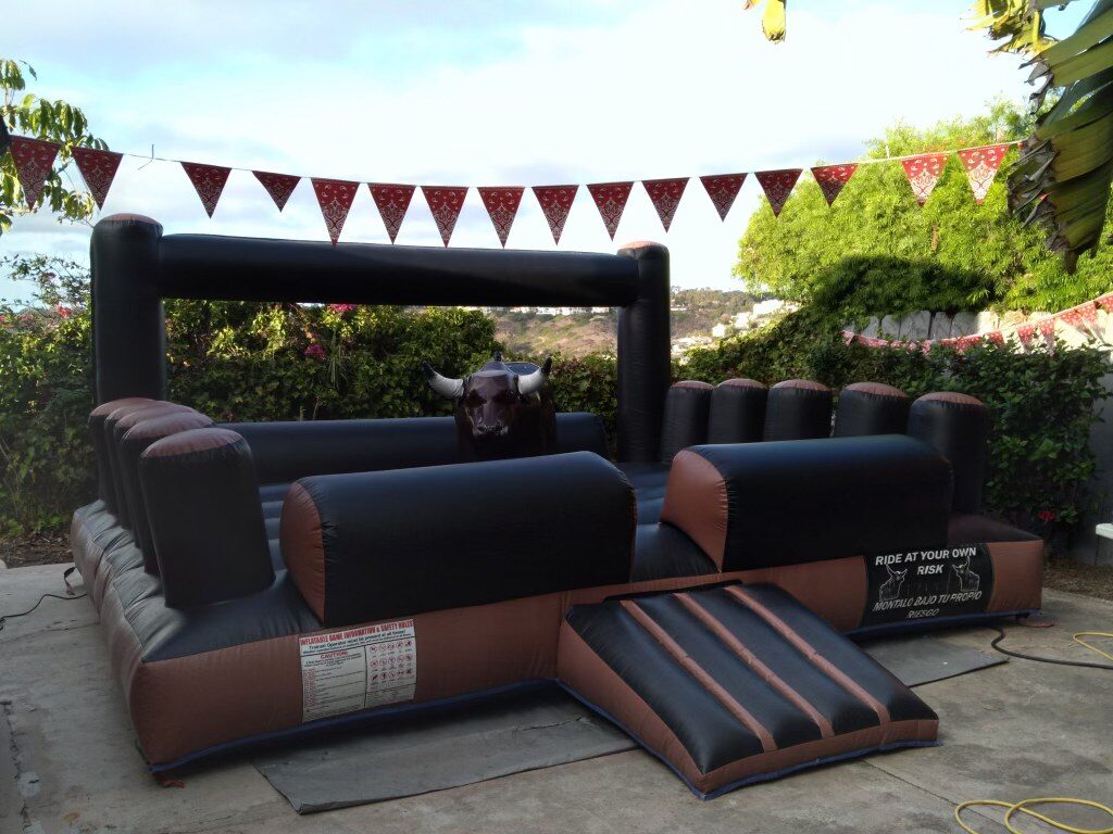 Mechanical bull rental in San Diego, 13x13 setup at a backyard party with bandana bunting overhead