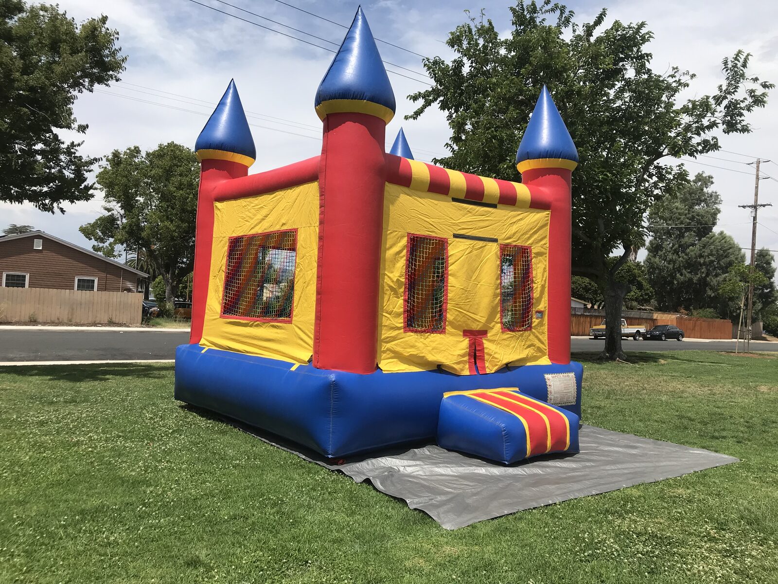 13x13 regular castle bounce house rental in San Diego — angled view showing the entry ramp and mesh safety windows