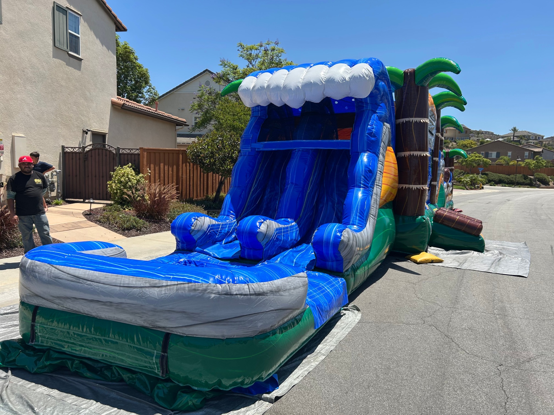 63ft tropical obstacle course rental in San Diego, front view of the dual-lane wave slide with landing pad