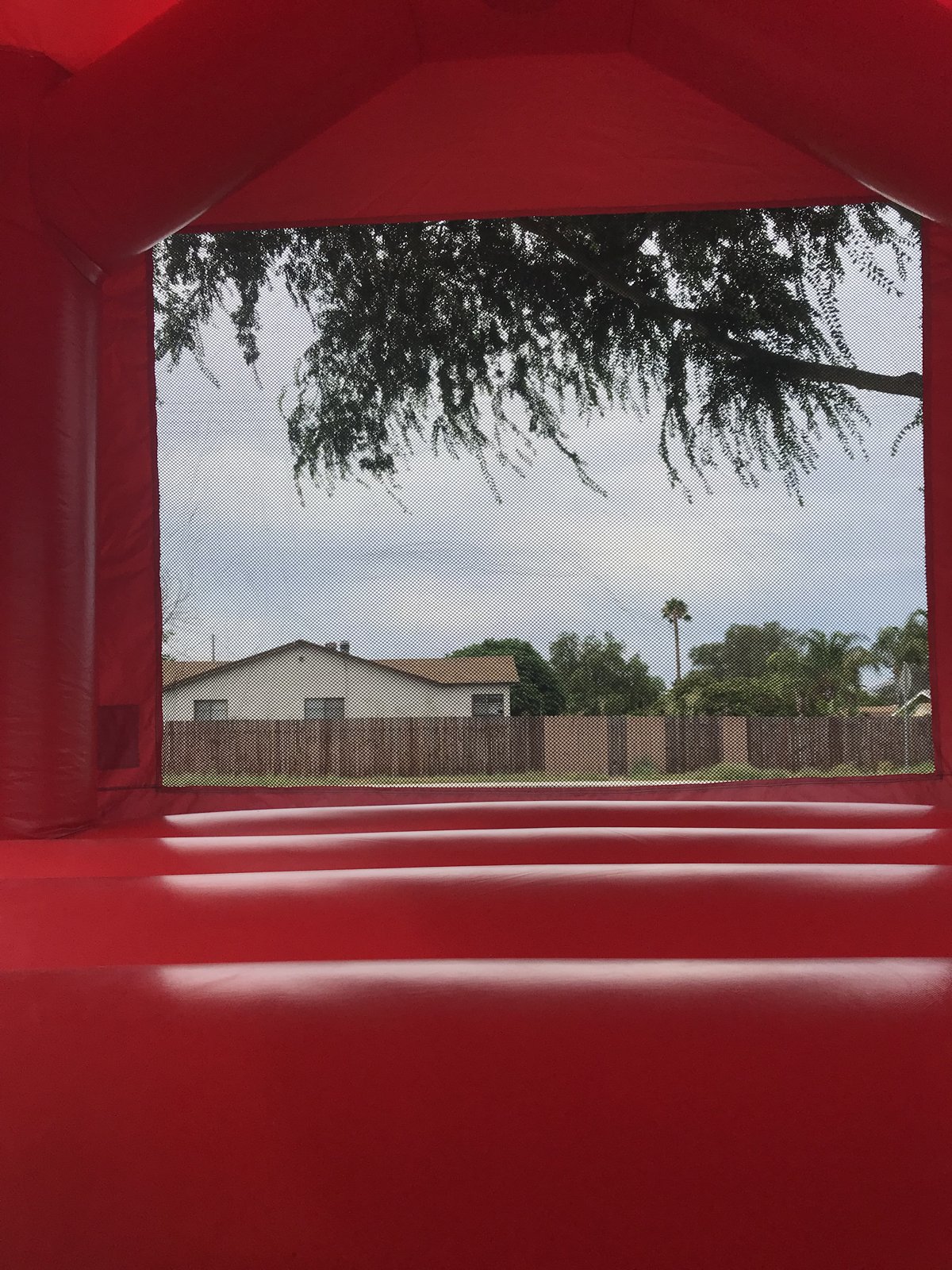 13x13 Hello Kitty bounce house rental in San Diego — inside view of the red jumping floor and large mesh safety window