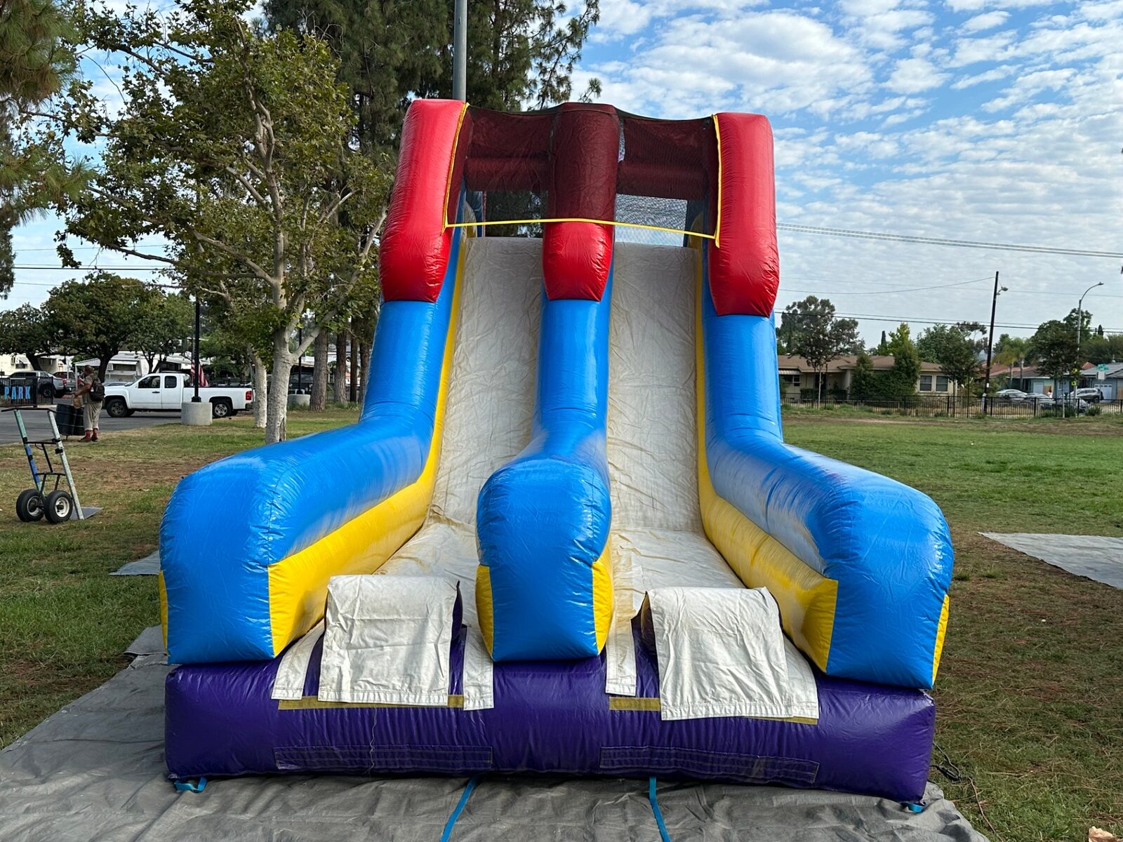 18ft dual lane monster obstacle course rental in San Diego, front view of the slide exit lanes on a park lawn