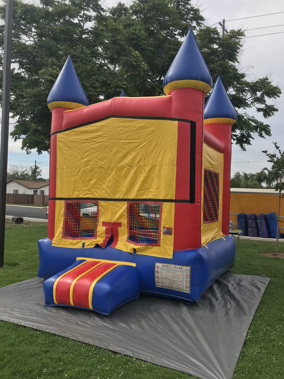 12x14 blue castle banner mini bounce house rental in San Diego, angled view of the striped entry step