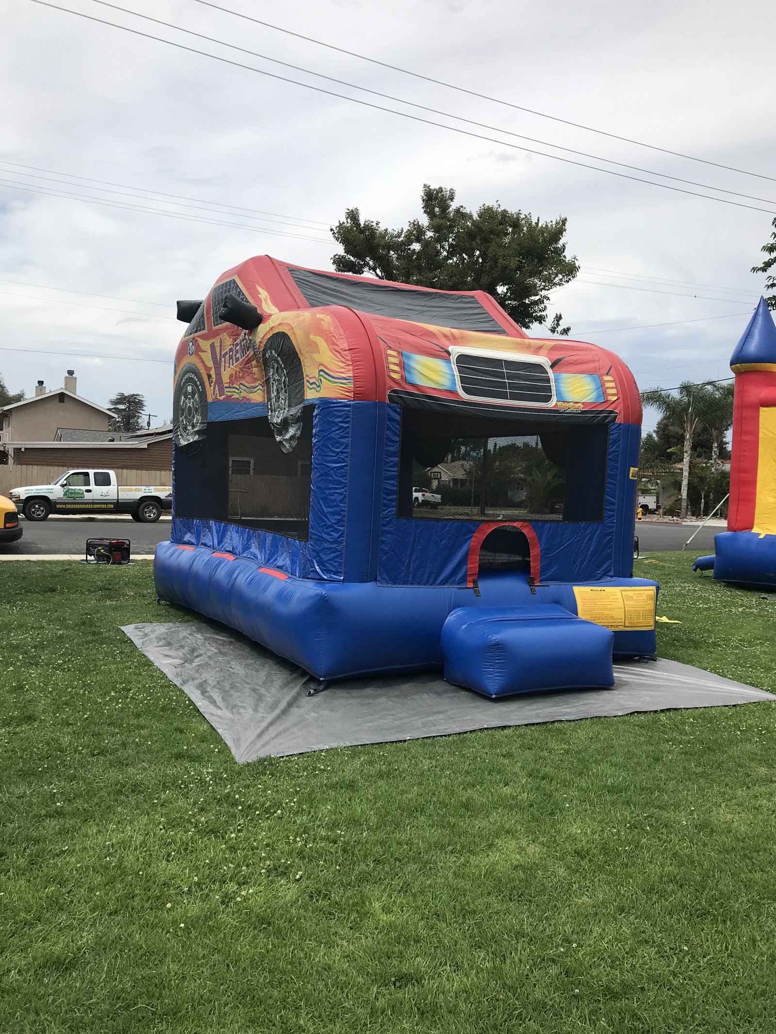 13x17 Xtreme Racer bounce house rental in San Diego — rear-angled view showing the mesh safety windows and entry ramp