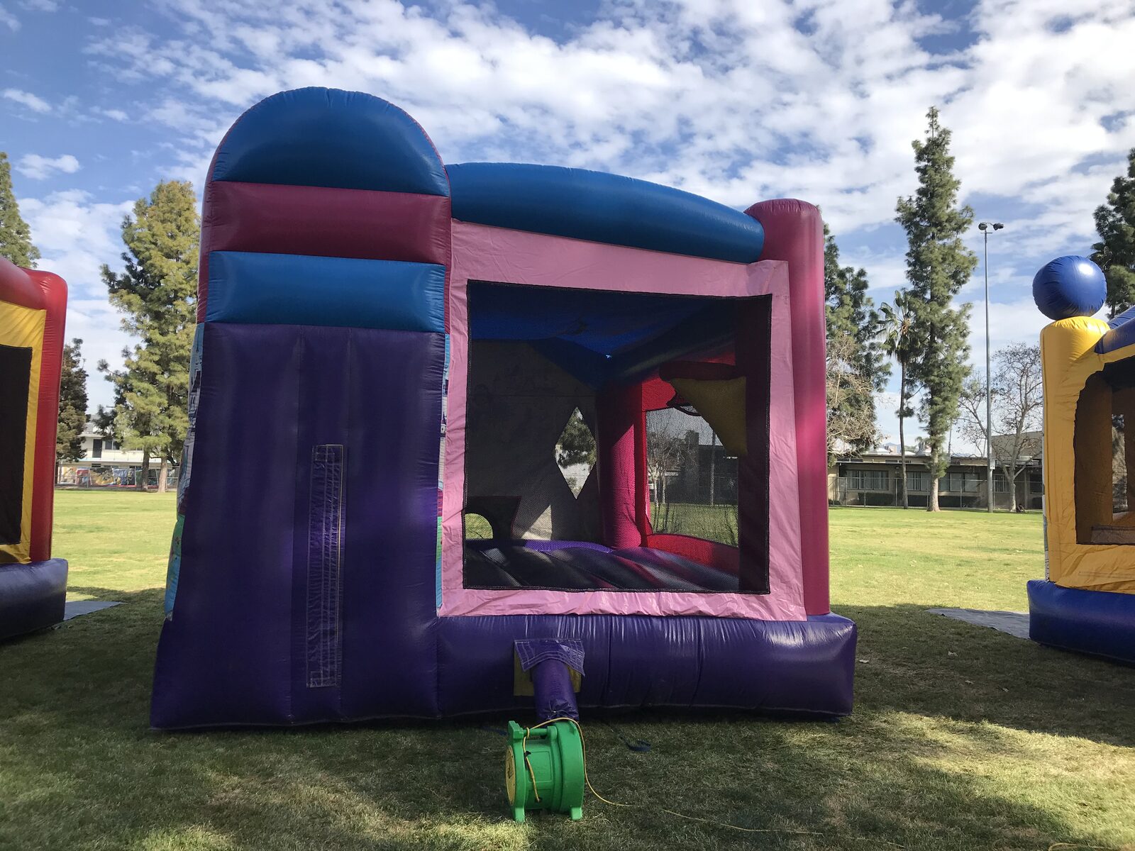 4n1 princess combo bounce house rental in San Diego, rear view showing the slide tower back, mesh opening and green blower hookup