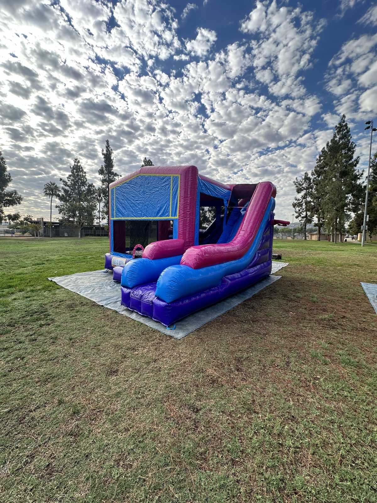 6n1 pink banner combo bounce house rental in San Diego, wide angled view of the pink and blue slide on a tarp