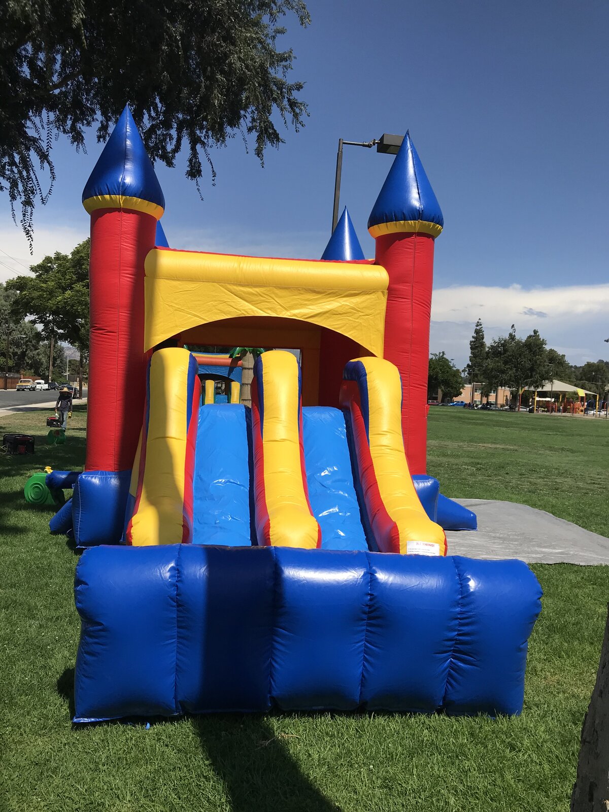 3n1 blue castle banner combo bounce house rental in San Diego, straight-on view of the dual slide lanes and inflatable landing bumper