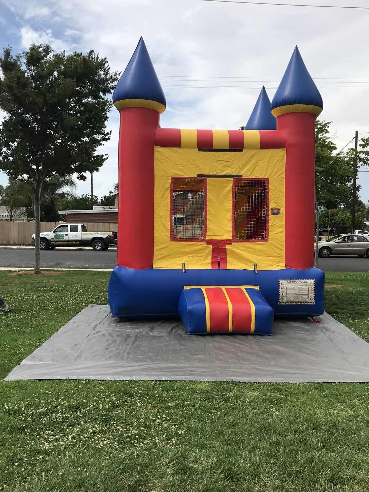 12x14 blue castle mini bounce house rental in San Diego, front view with blue cone turrets and red striped entry step