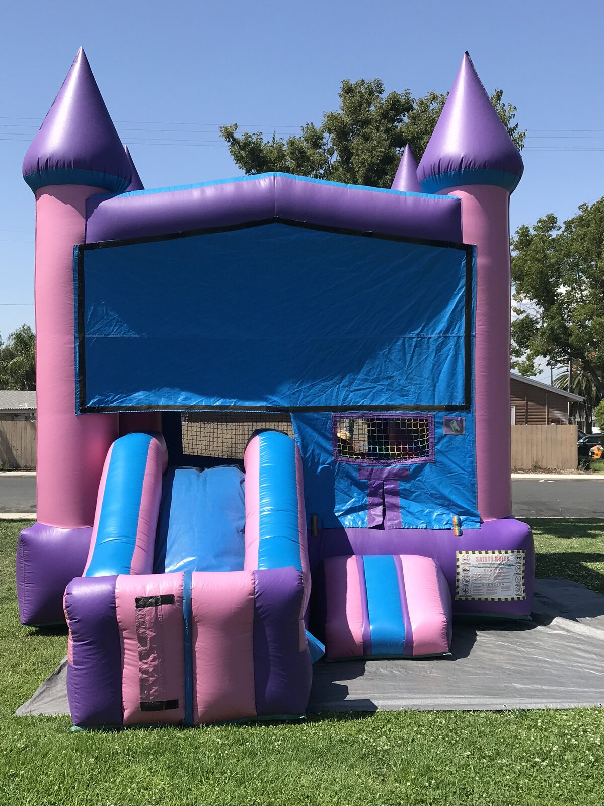 2n1 pink castle banner combo bounce house rental in San Diego, straight-on front view of the pink and purple castle with the slide on the front and a blank banner panel
