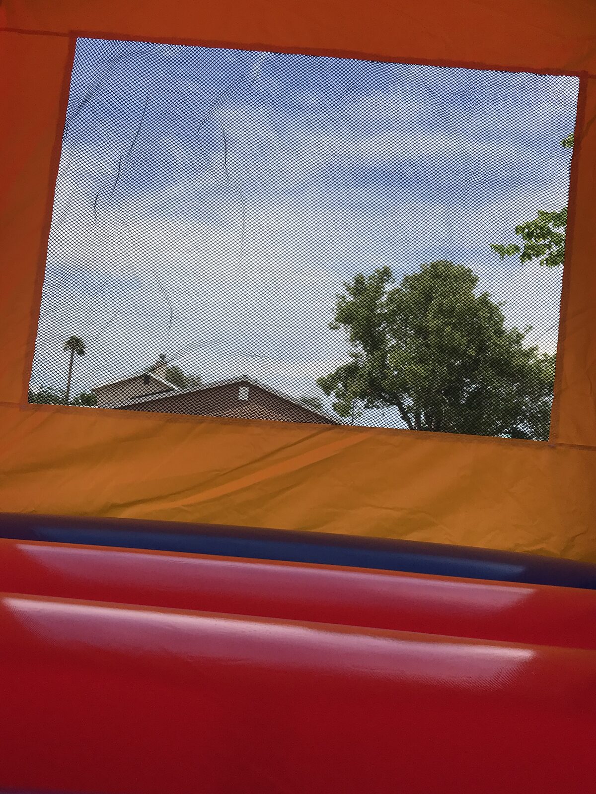12x14 multi color castle mini bounce house rental in San Diego, interior view looking out through the mesh window