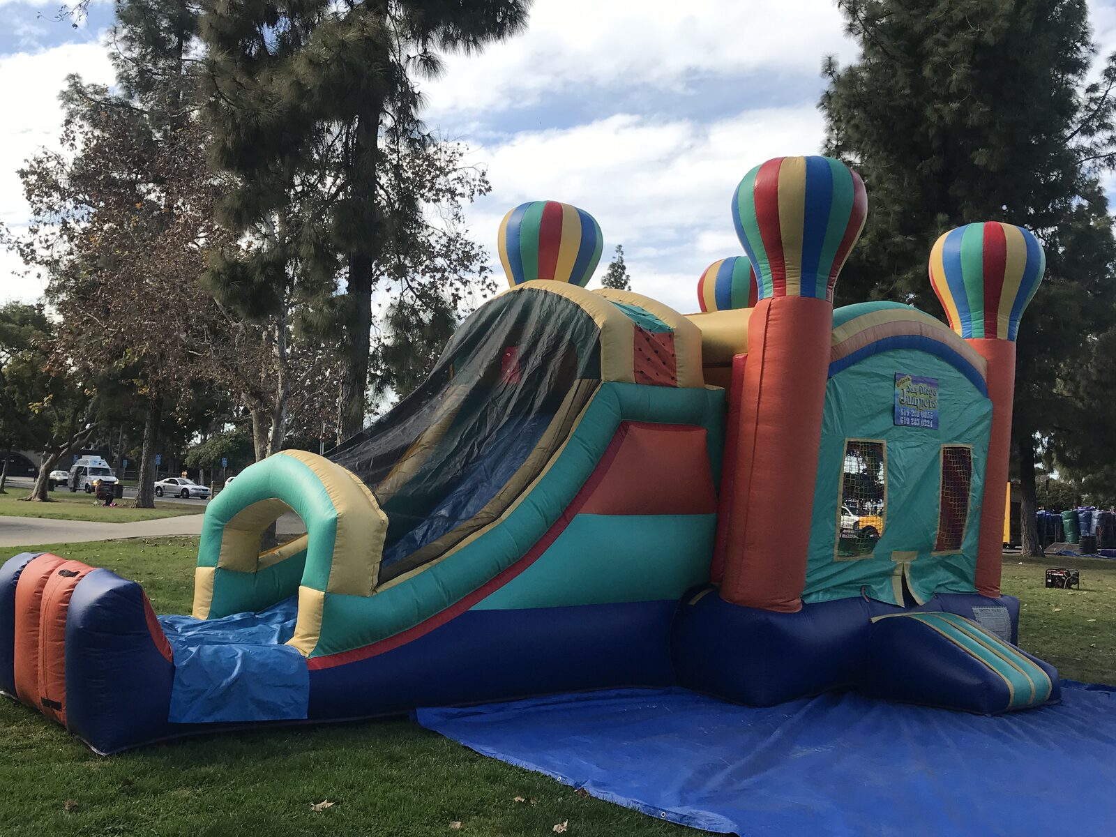 4n1 summer balloon combo bounce house rental in San Diego, side view of the covered slide lane and climb-up on grass