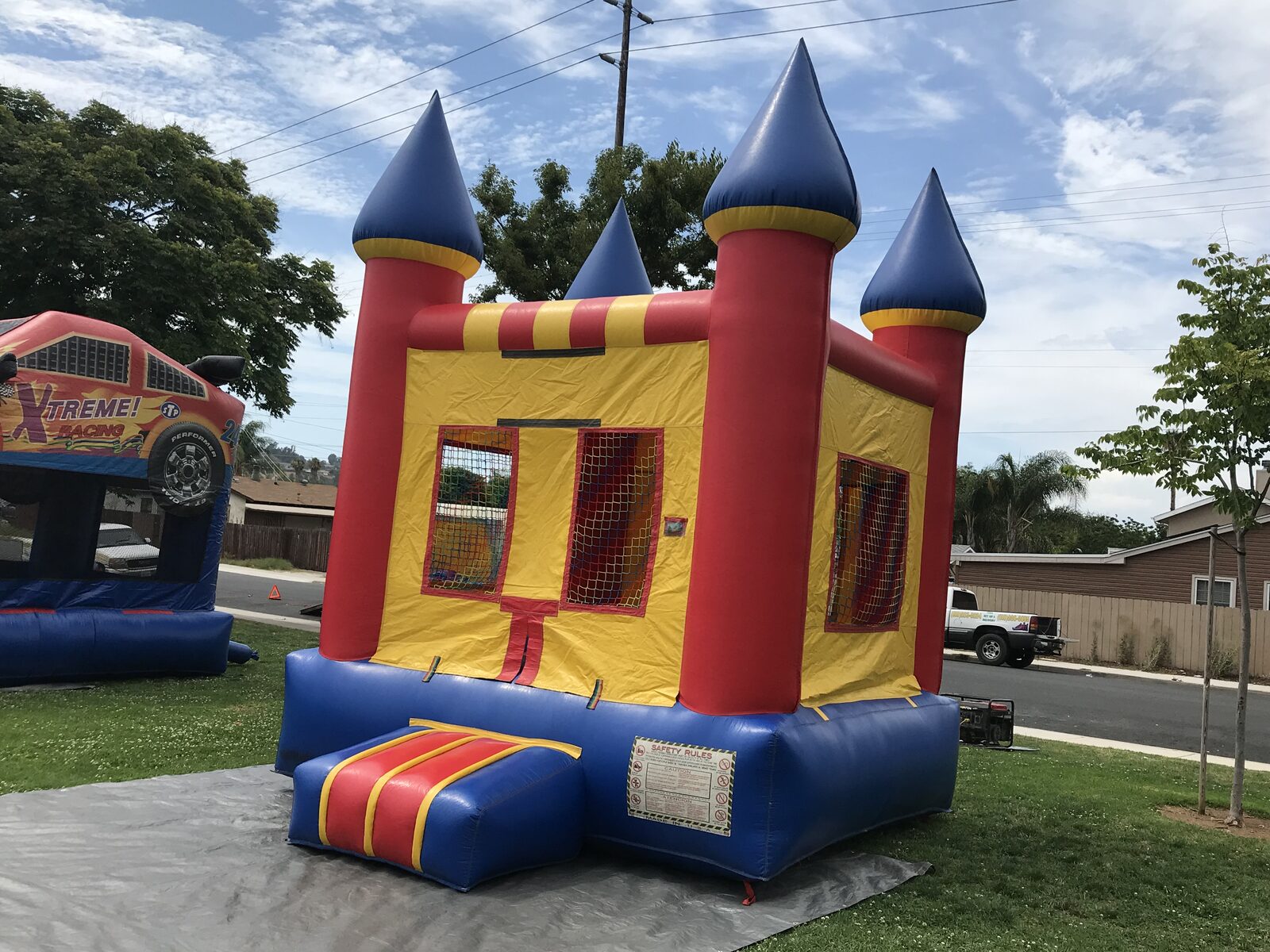 12x14 blue castle mini bounce house rental in San Diego, wide view of the castle set up on a lawn